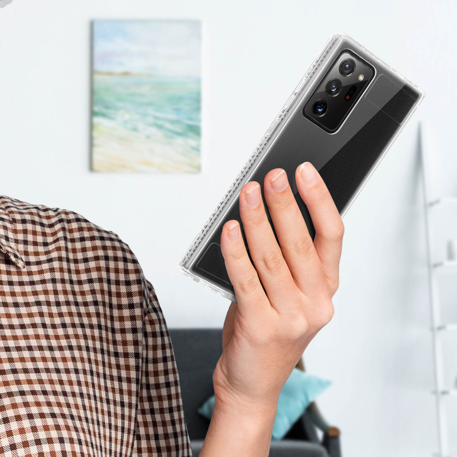 Personne tenant une coque transparente. La coque a un dos transparent et une zone noire à motifs.