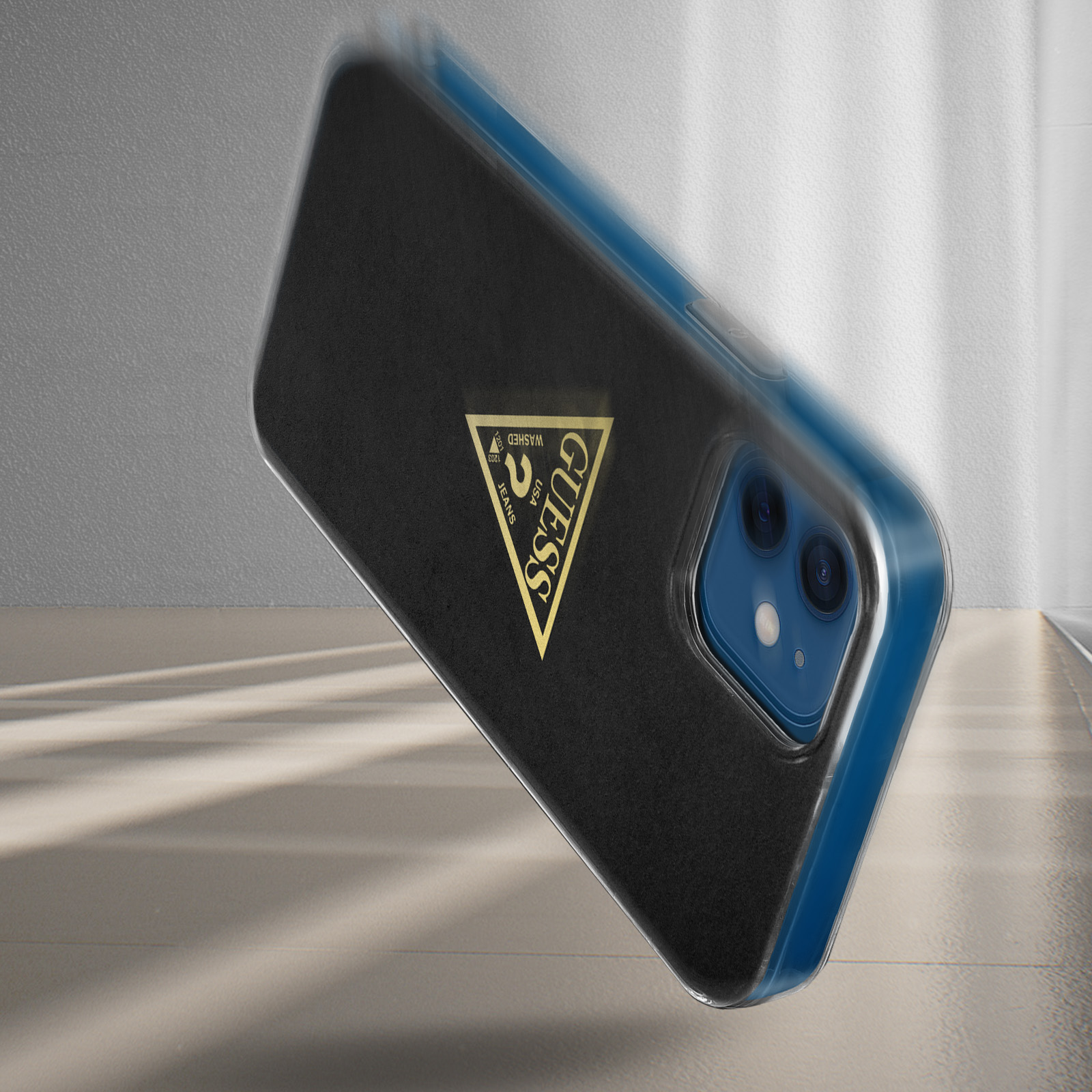 Telefono in una custodia nera con il logo Guess. Lo sfondo è sfocato e mostra uno schema di colori blu e bianco.