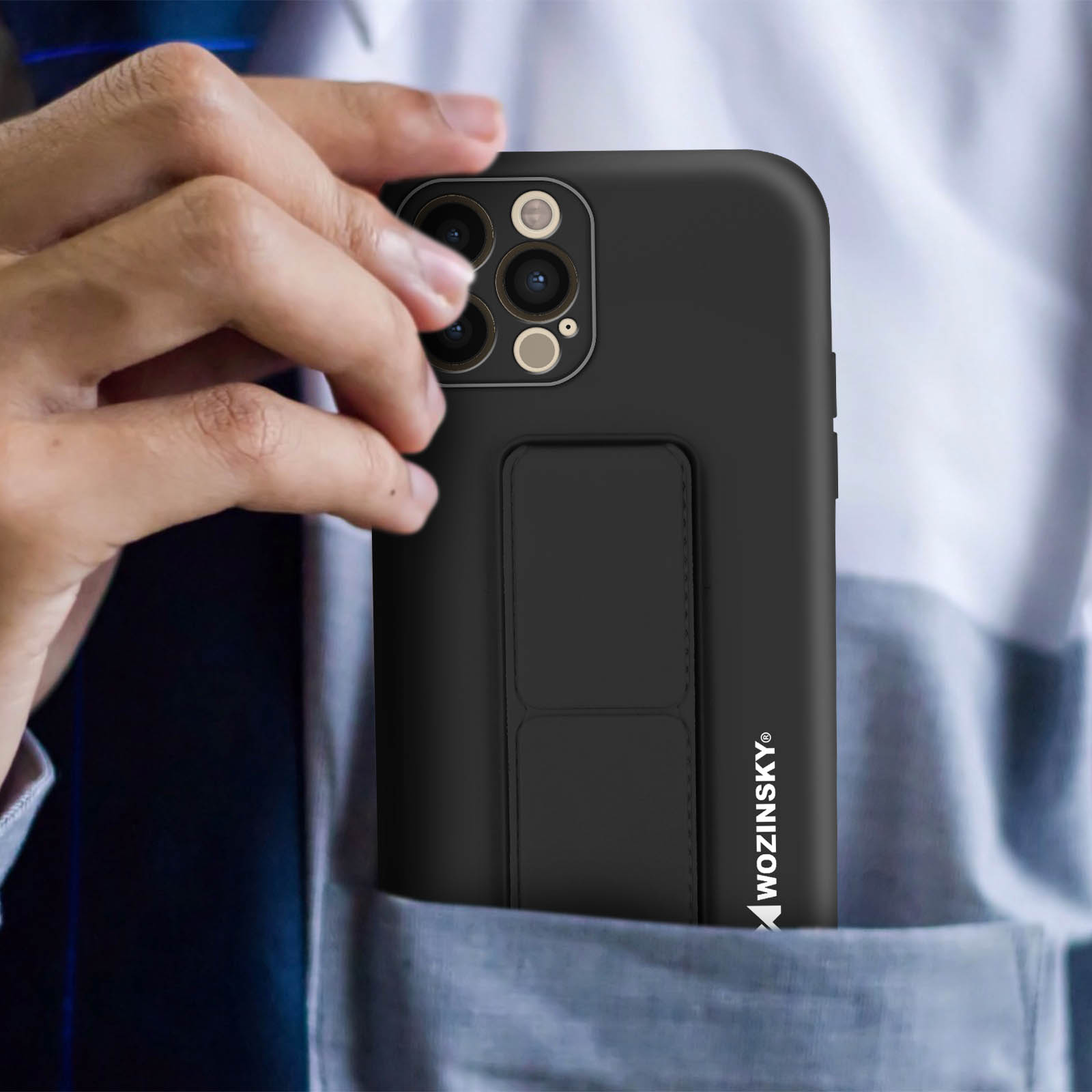 Dłoń w kieszeni, czarne etui z uchwytem. Telefon z obiektywami. Nazwa marki po prawej.