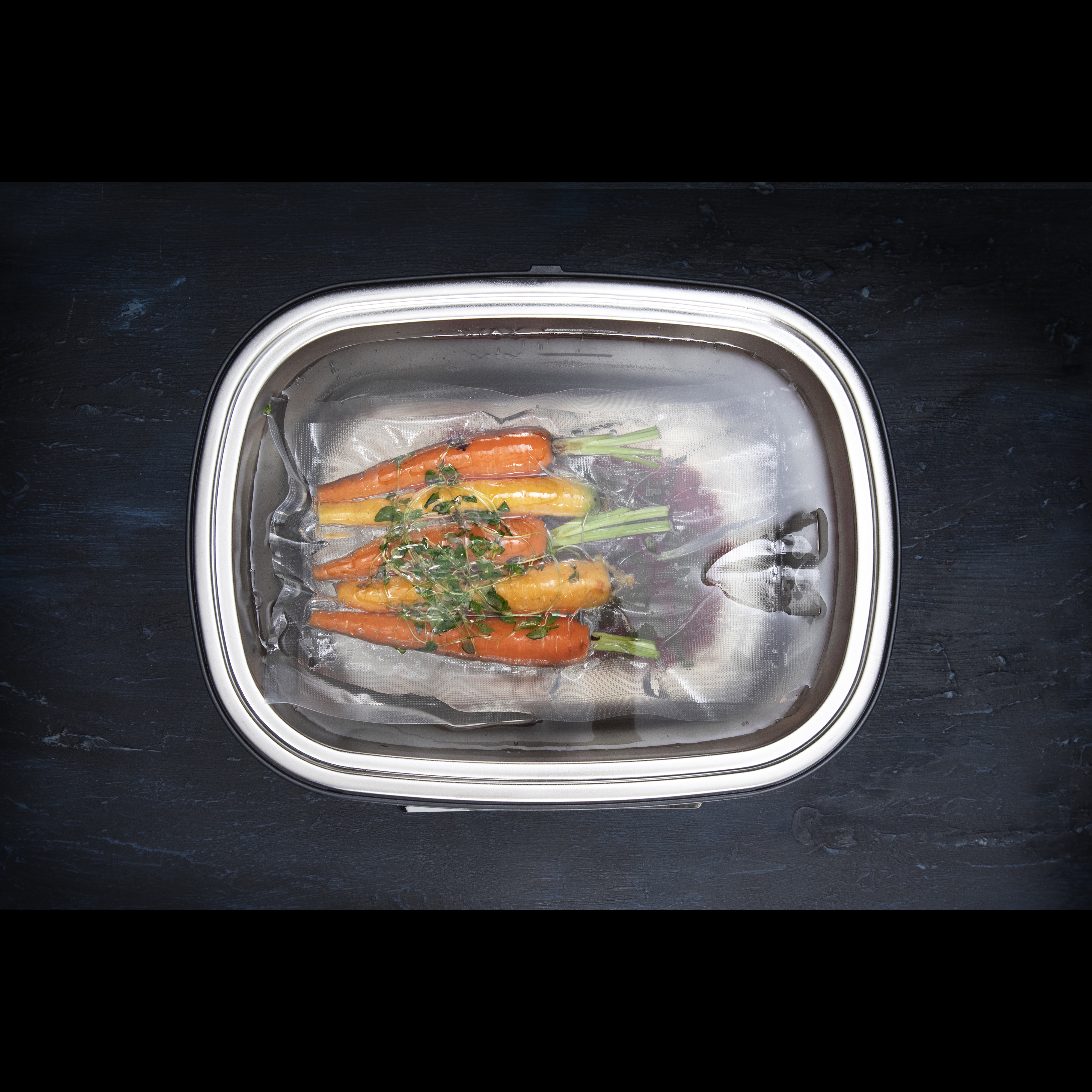 Carrots in a vacuum-sealed bag inside of a metal container.