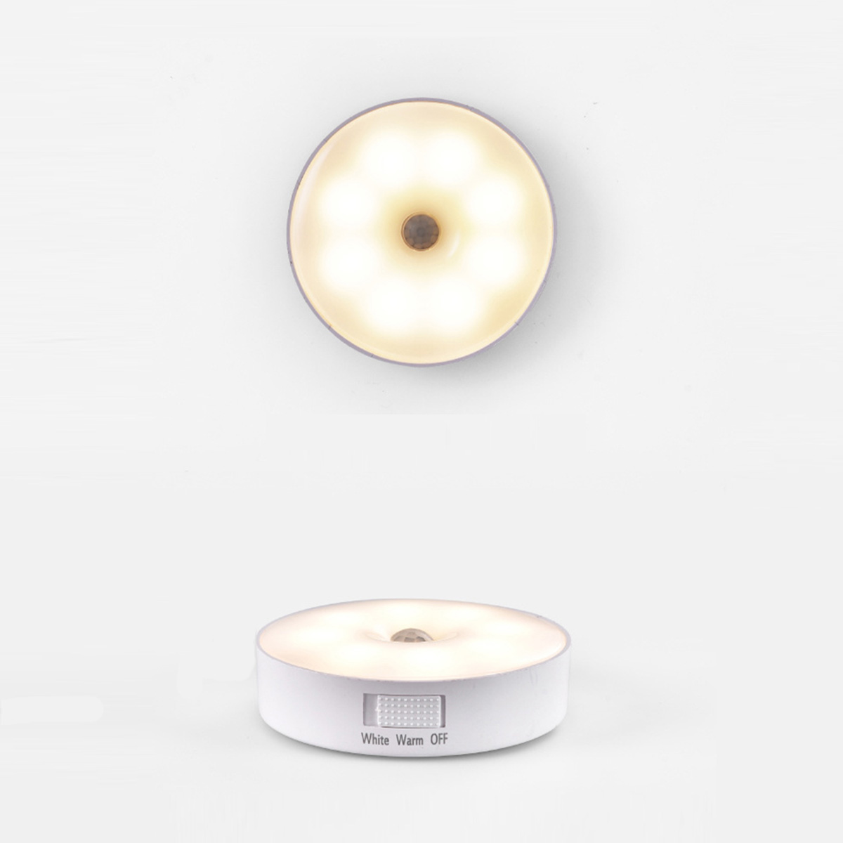 Dos luces nocturnas LED blancas y redondas; una muestra la luz, la otra el interruptor.