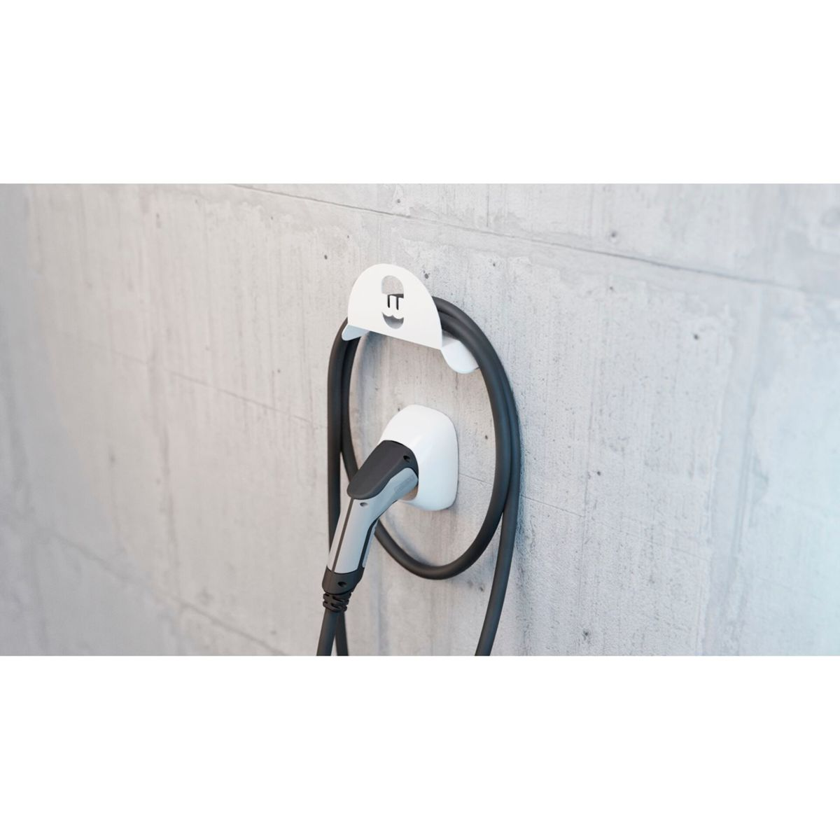 Weiße Ladestation und Kabel an einer Betonwand. Weißer Hintergrund.