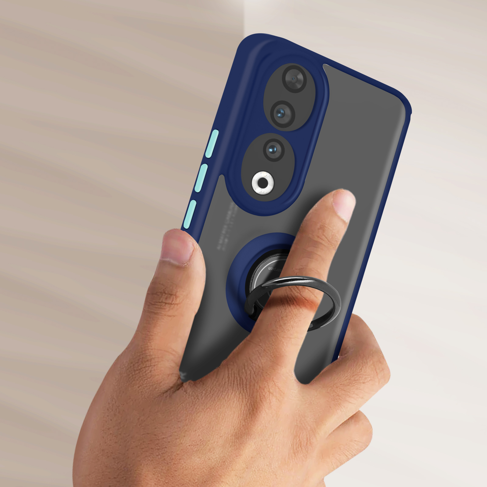 Una mano tiene in mano un telefono con una custodia blu e un supporto ad anello. La fotocamera è visibile.