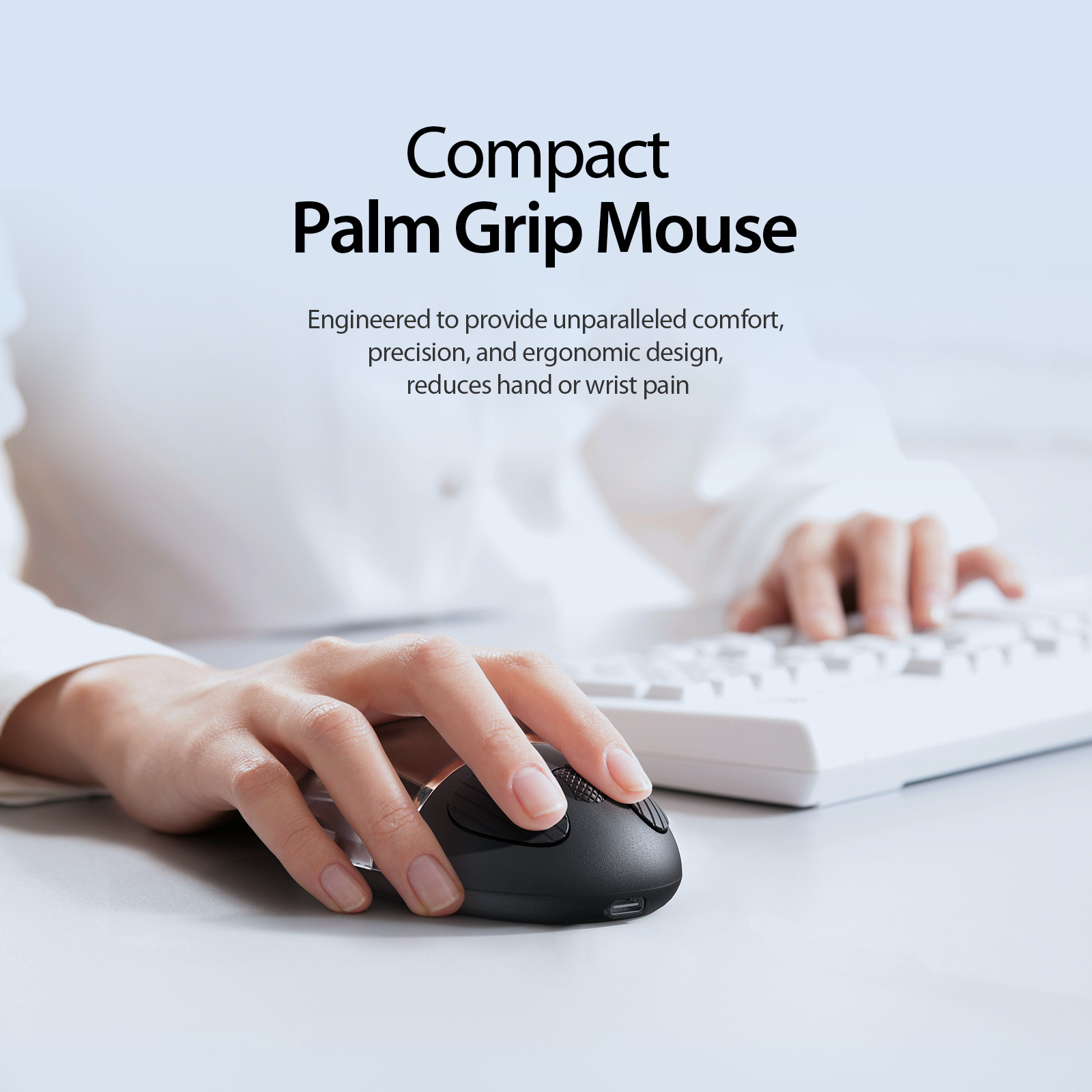 Hände an einer Tastatur, mit einer schwarzen, kompakten Palm Grip Maus.