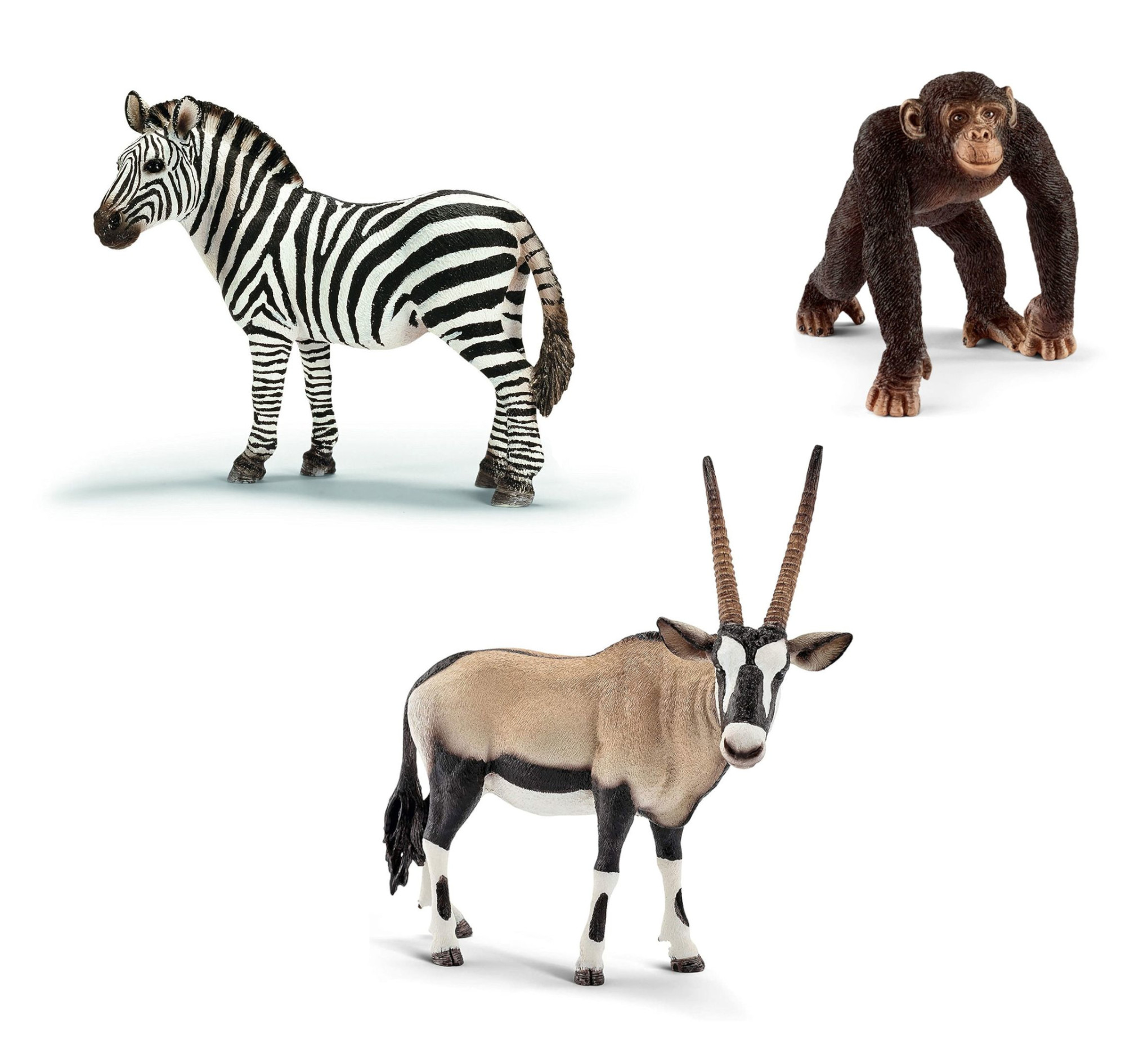Drei Spielzeugtiere: ein Zebra, ein Schimpanse und eine Oryxantilope. Auf weißem Hintergrund.