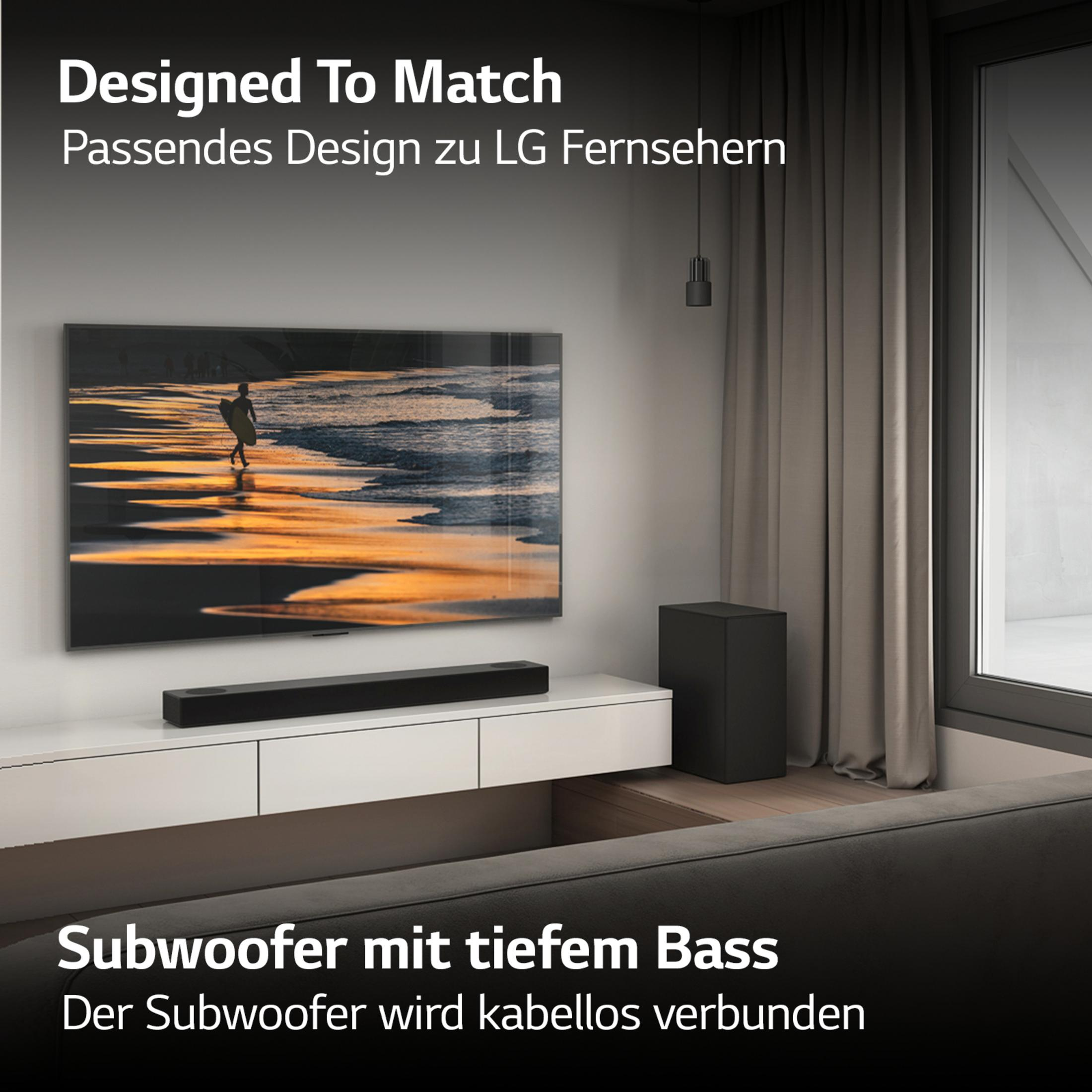 Ein Fernseher auf einem weißen Schrank, mit einer Soundbar darunter und einem Subwoofer. Fenster im Hintergrund.