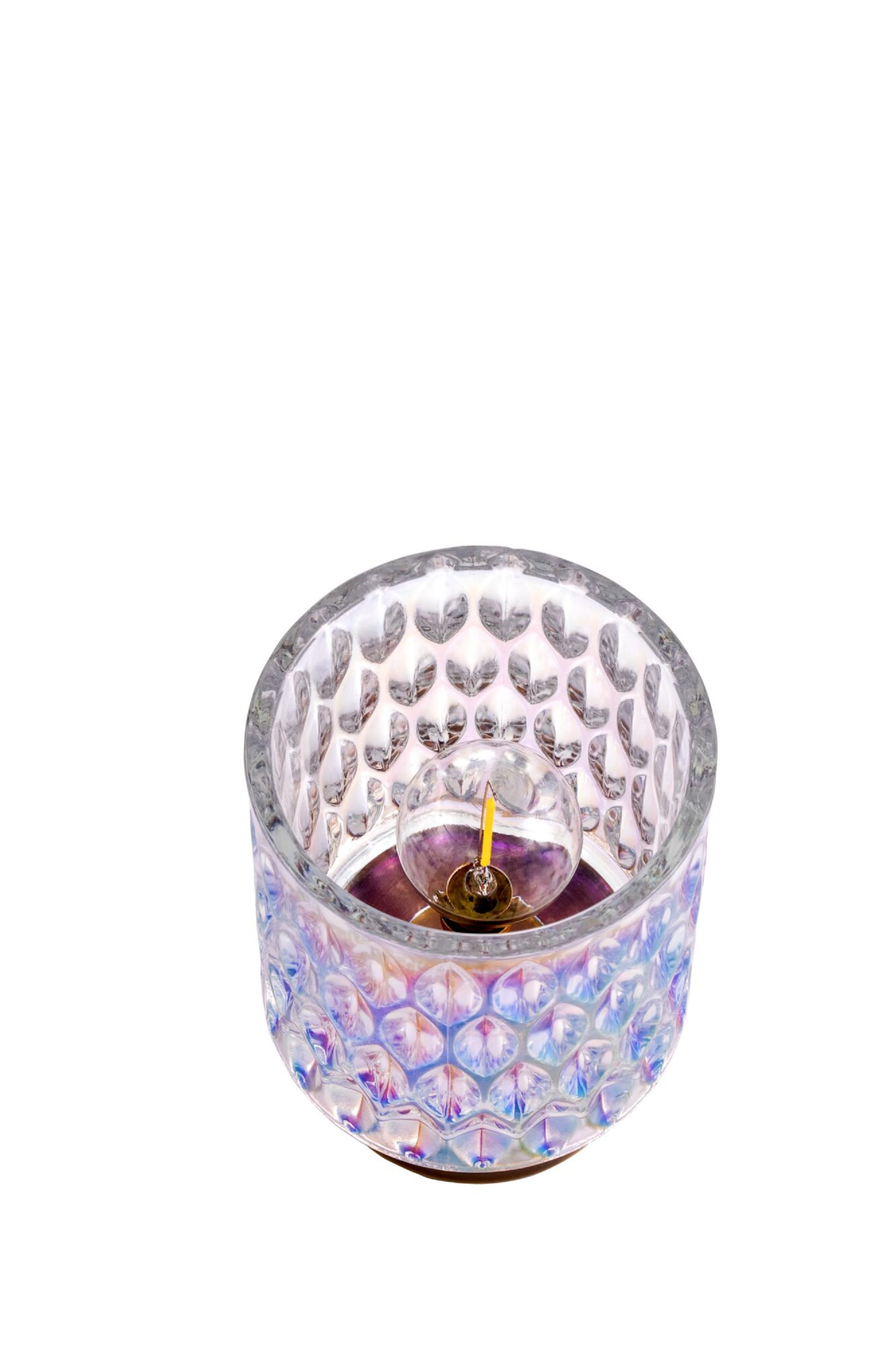 Przezroczysty szklany świecznik z unikalnym, iridiscentnym wykończeniem i zapalonym knotem w środku.