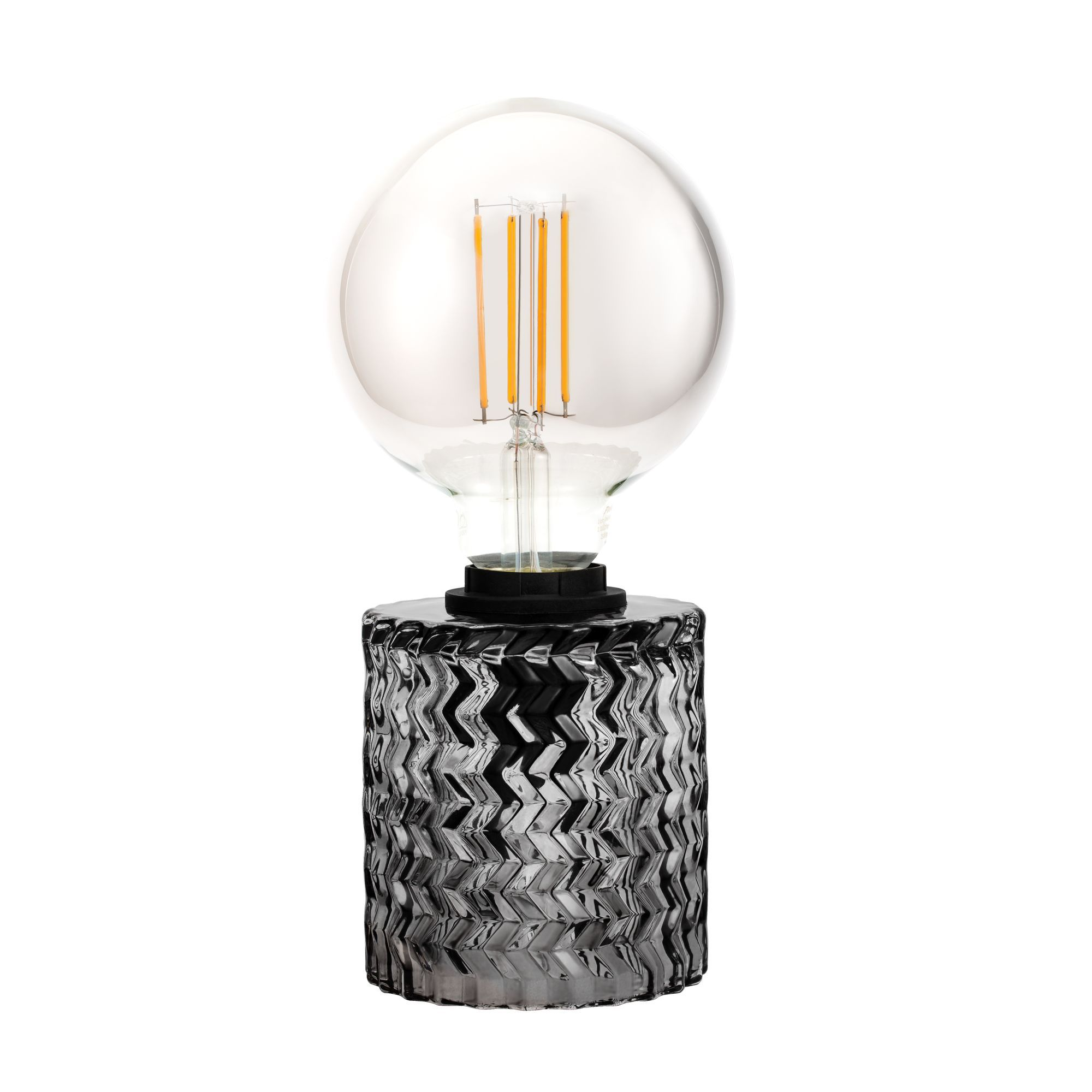 Dekoracyjna lampa stołowa z przezroczystą żarówką i wzorzystą podstawą.