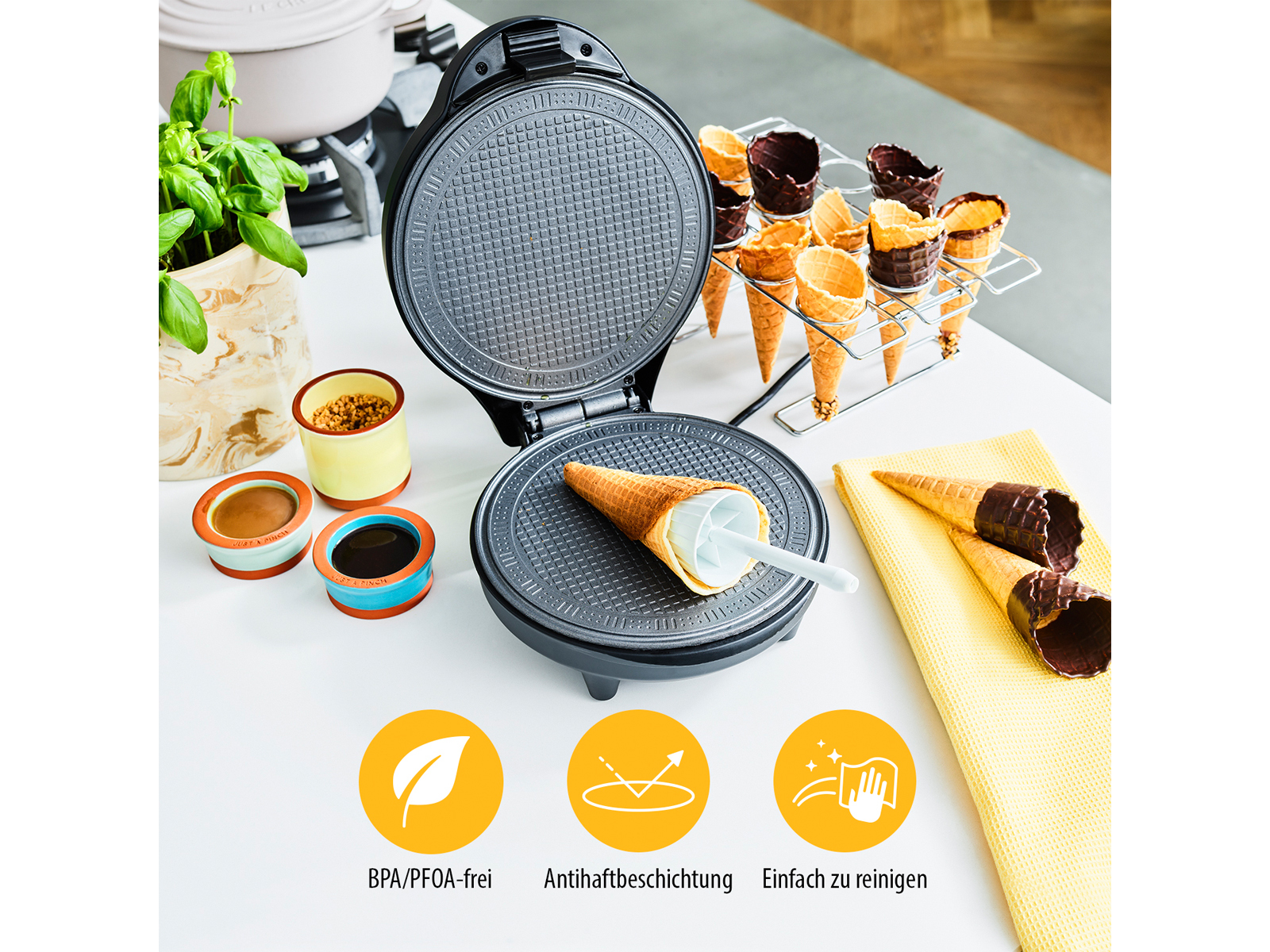 Waffeleisen mit Waffeln, Eiswaffeln und Zutaten. Weiße Arbeitsplatte und Küche.
