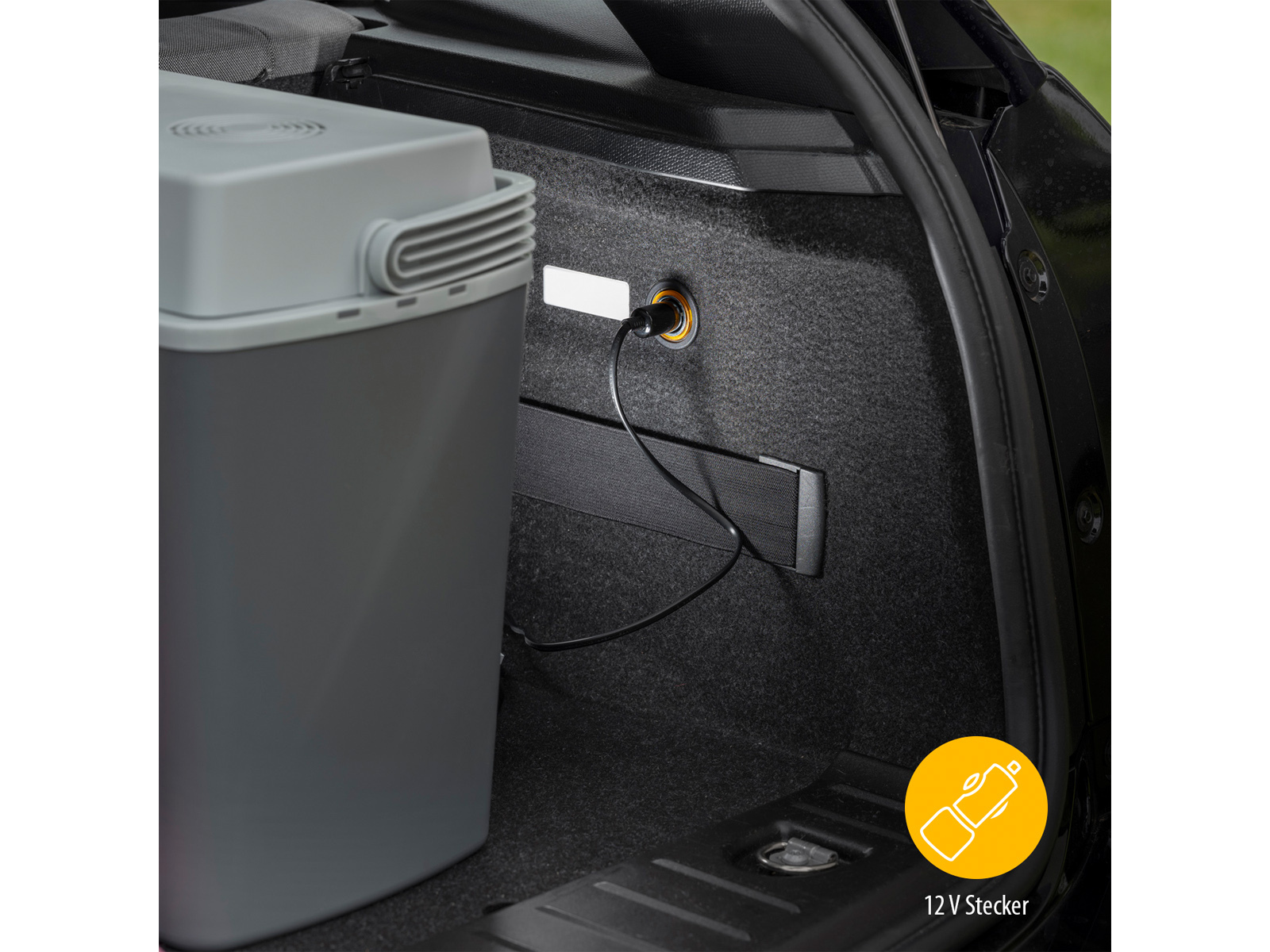 Bagagliaio dell'auto con un refrigeratore collegato a una presa da 12V. Anche una luce è collegata.