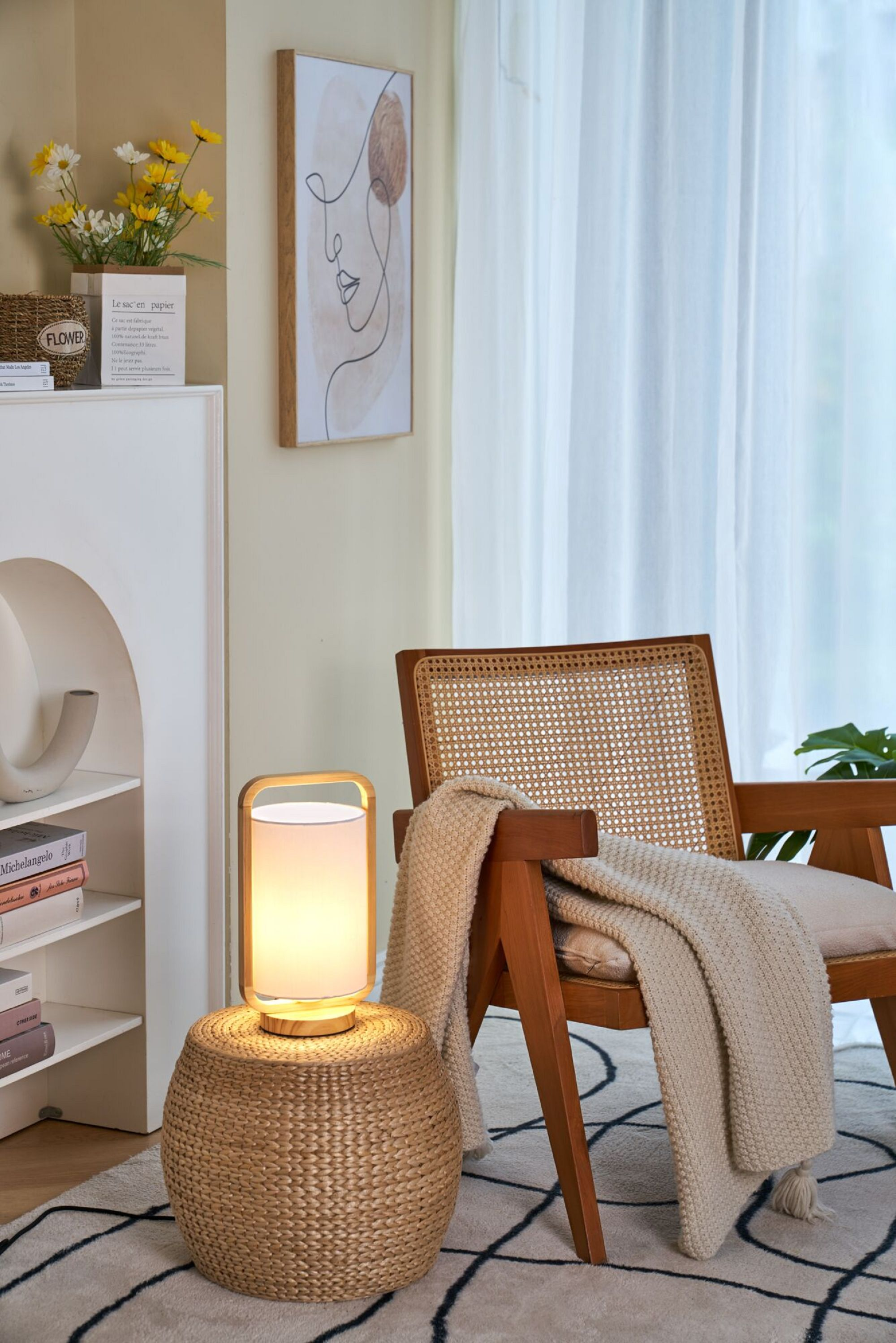 Lampa na stojaku w stylu rattanowym, obok krzesła, dzieła sztuki i innych dekoracji, jasna i przewiewna.