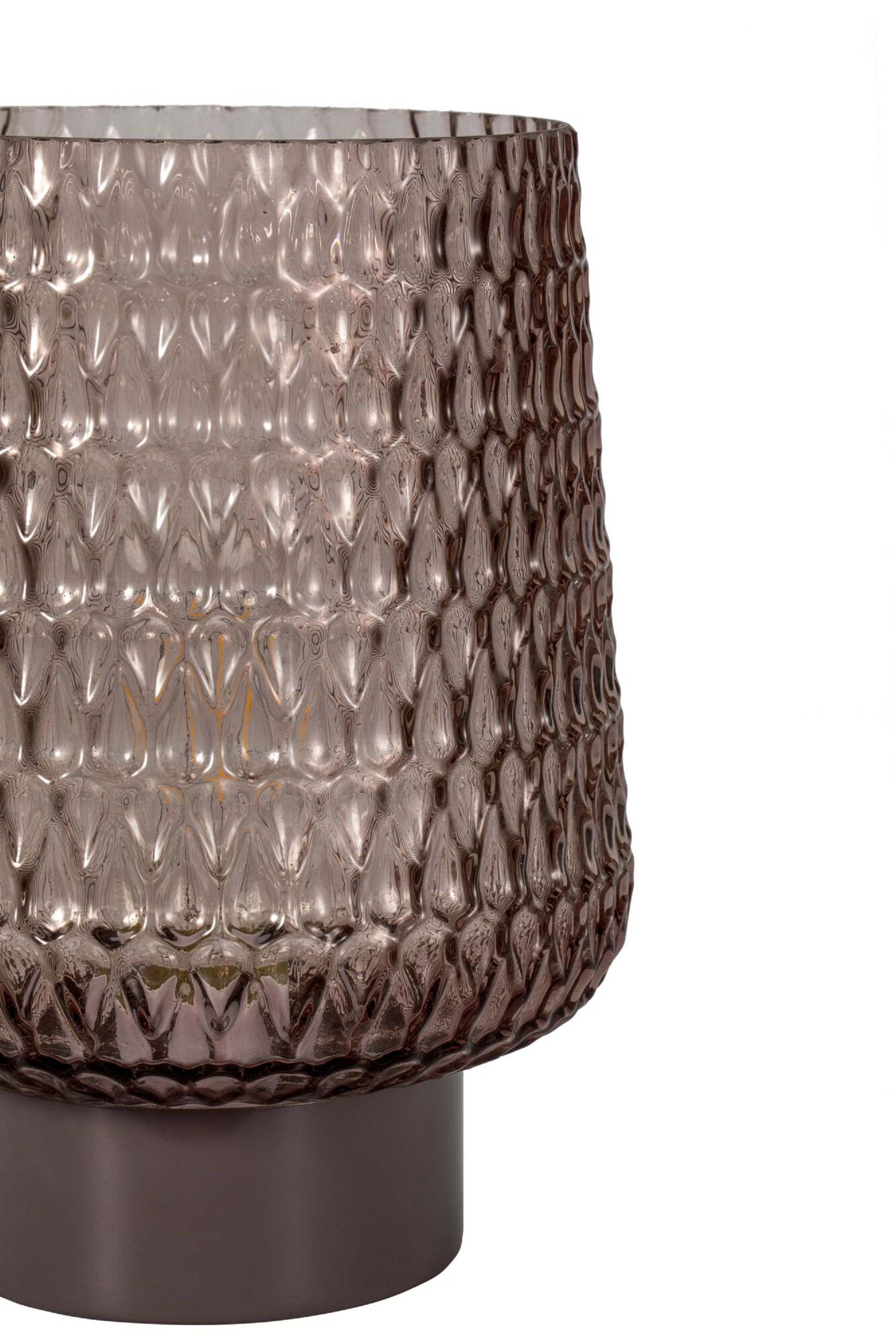 Teksturowana szklana lampa z metalową podstawą.