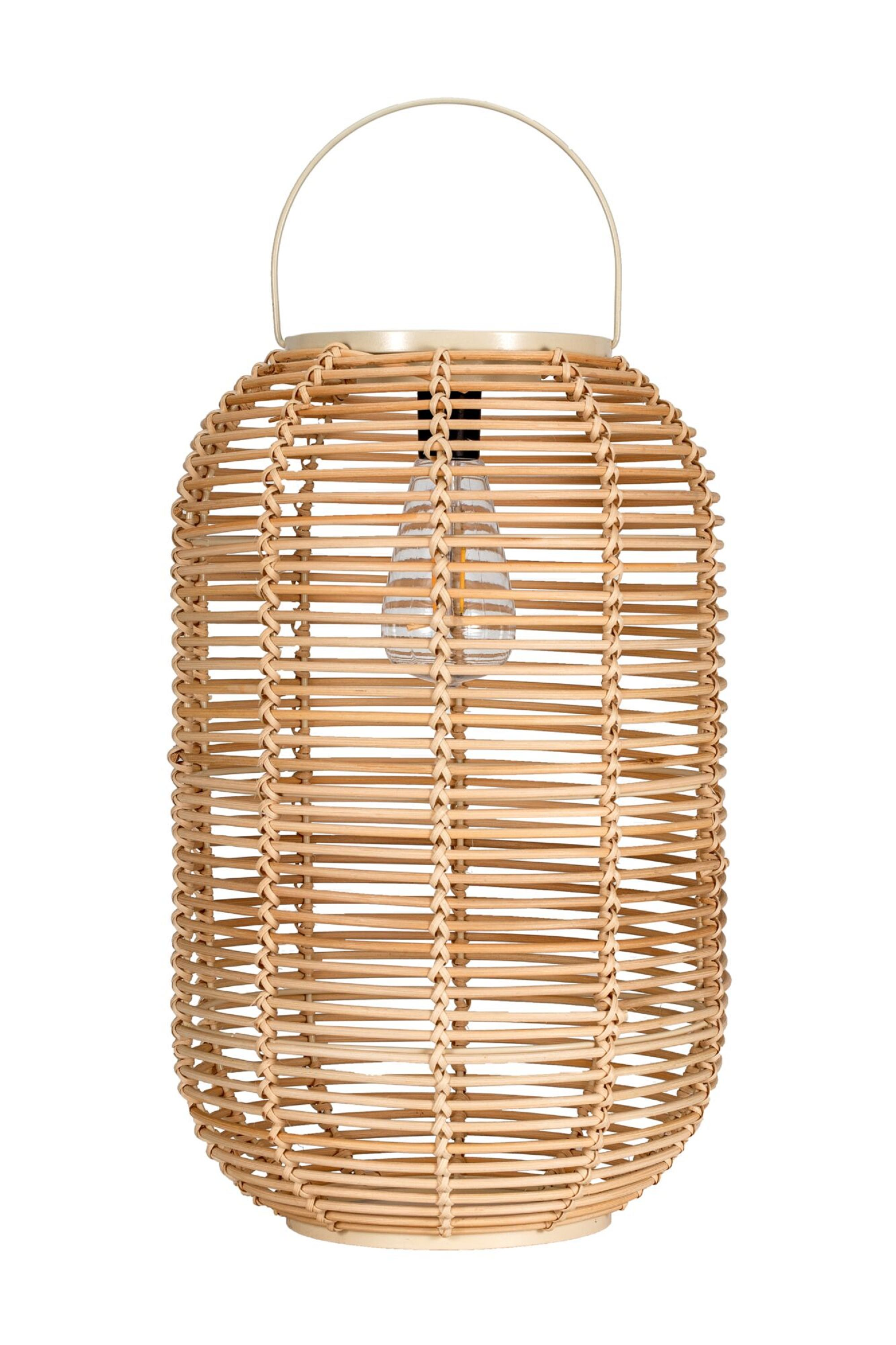 Wiklinowa latarnia z uchwytem i żarówką w środku. Latarnia jest cylindryczna.