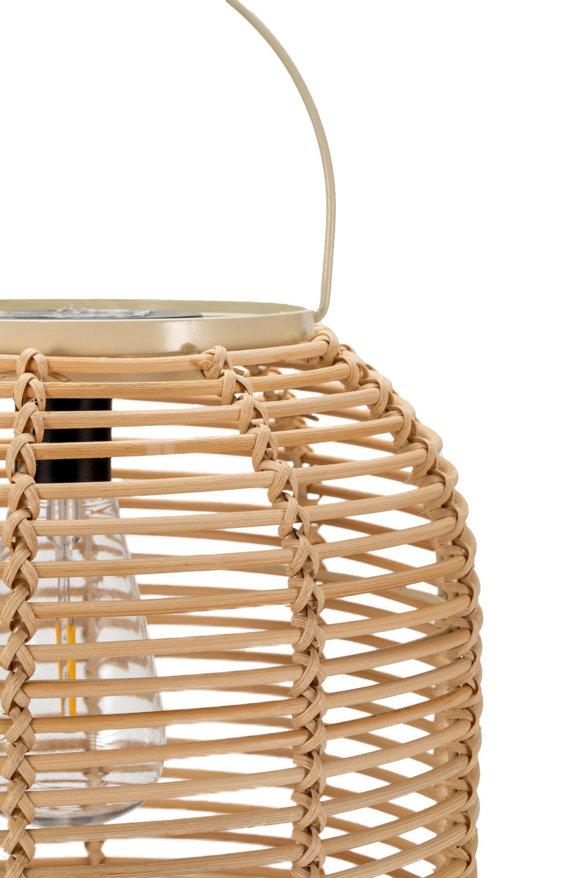 Lampion z rattanu z uchwytem i żarówką w środku. Tło jest białe.