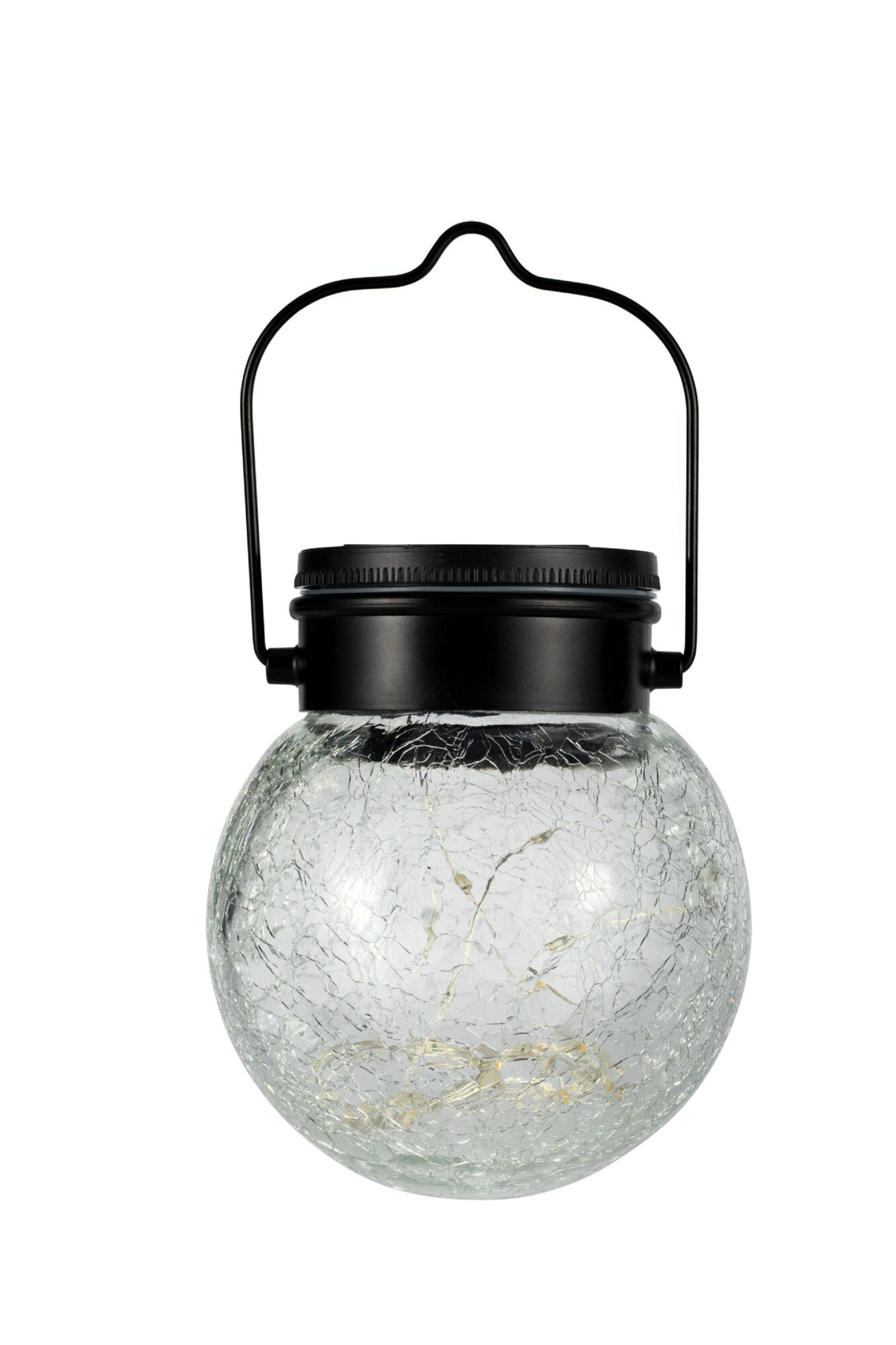 Latarnia ze szklanego słoika z łańcuchem świetlnym i czarnym uchwytem, białe tło.