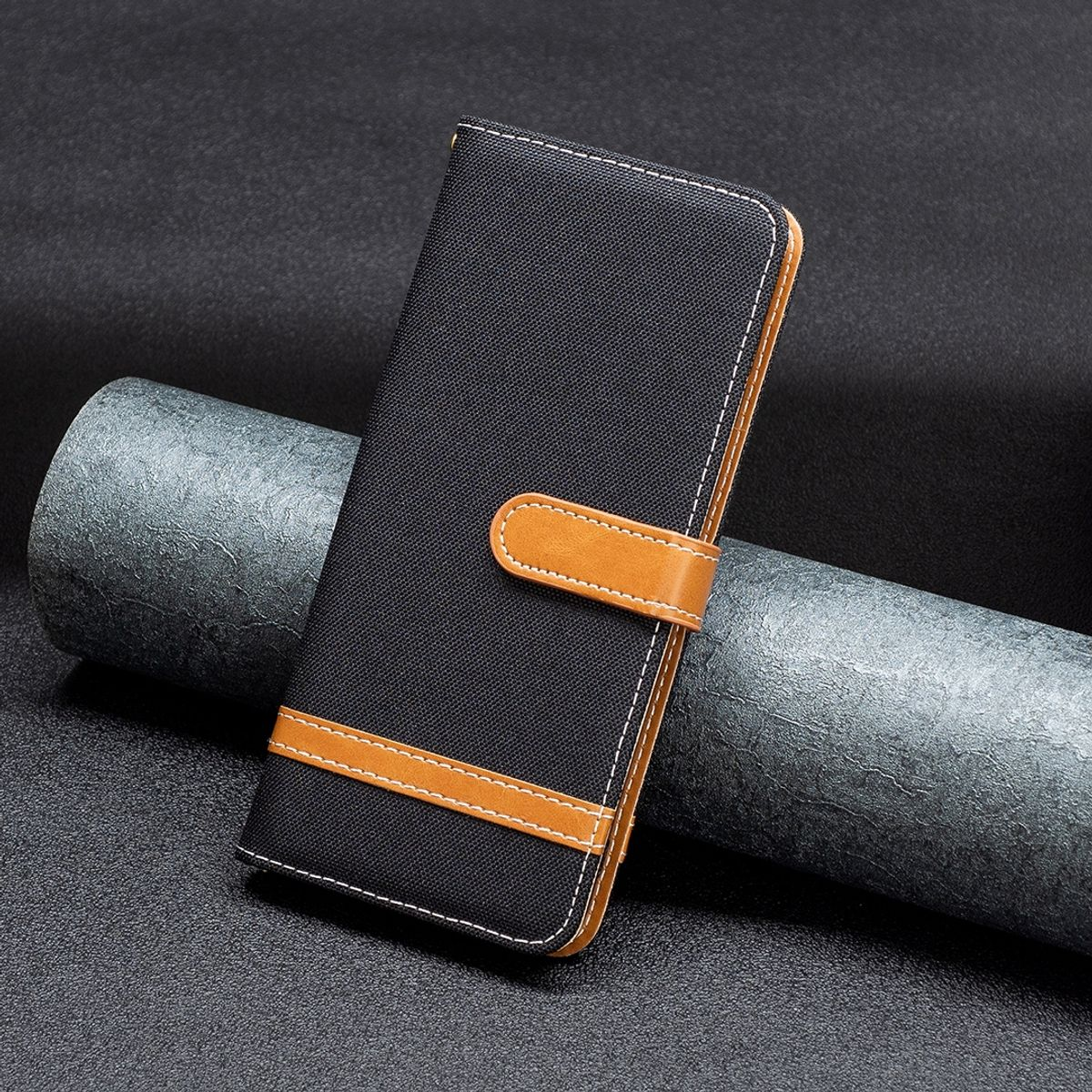 Eine schwarze Handyhülle mit Textur, einem braunen Riemen und einem Verschluss.