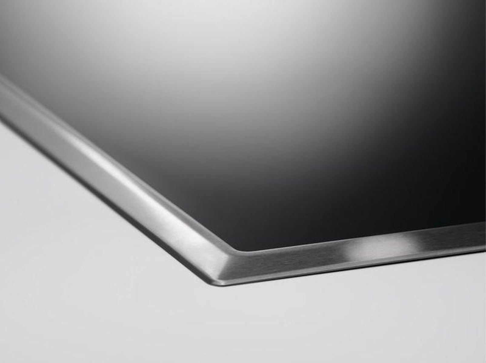 Czarna i srebrna płyta kuchenna, zbliżenie. Białe tło.