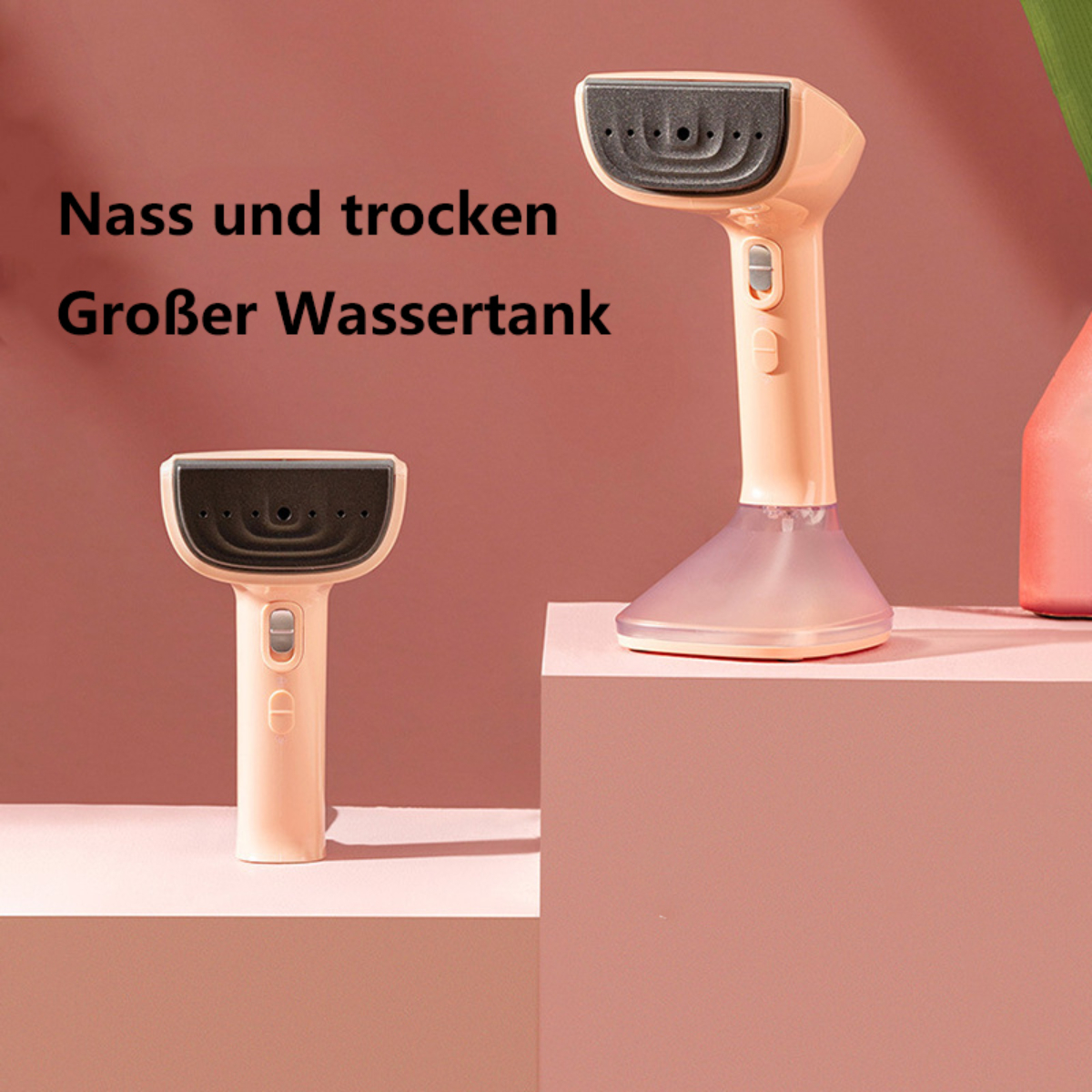 Zwei kleine, hellfarbige Kleidungsdampfer stehen auf einer rosa Oberfläche. Text: 'Nass und trocken' und 'Großer Wassertank'.