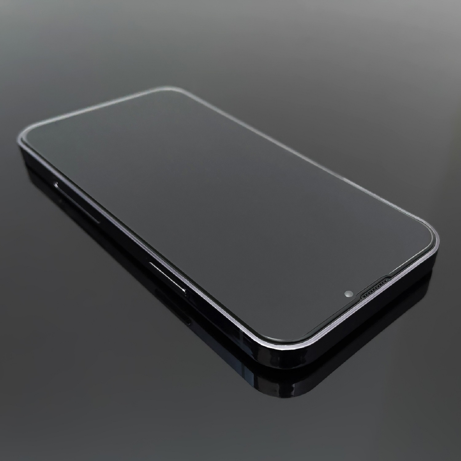 Ein schwarzes Smartphone mit schlankem Design, das sich auf einer glänzenden, dunklen Oberfläche spiegelt.