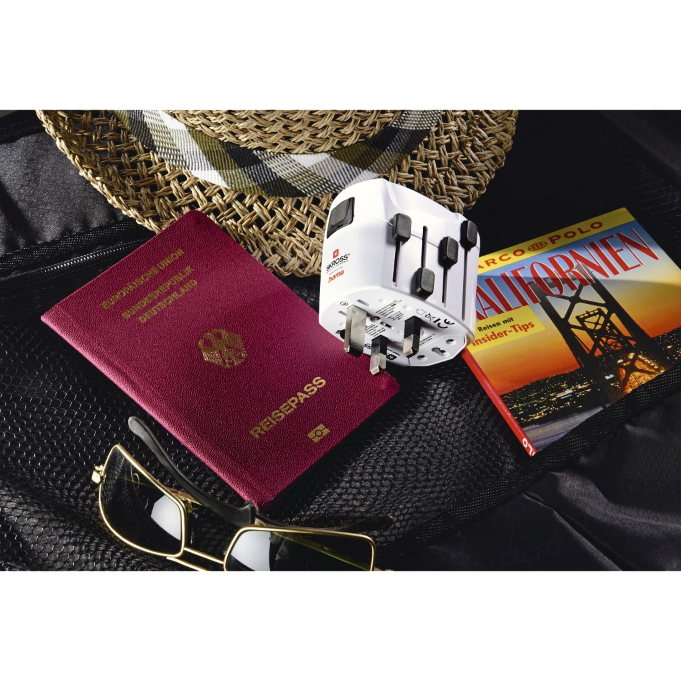 Articoli da viaggio: passaporto, occhiali da sole, adattatore e rivista. Tutto in una borsa da viaggio nera.