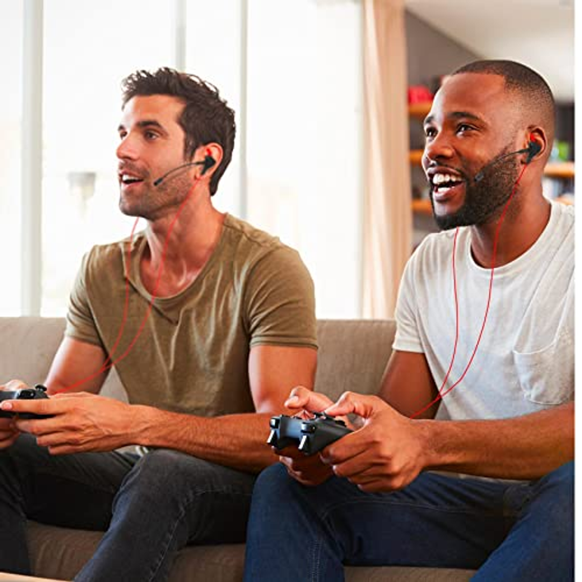 Dwóch mężczyzn grających w gry ze słuchawkami, siedzących na kanapie, z kontrolerami.