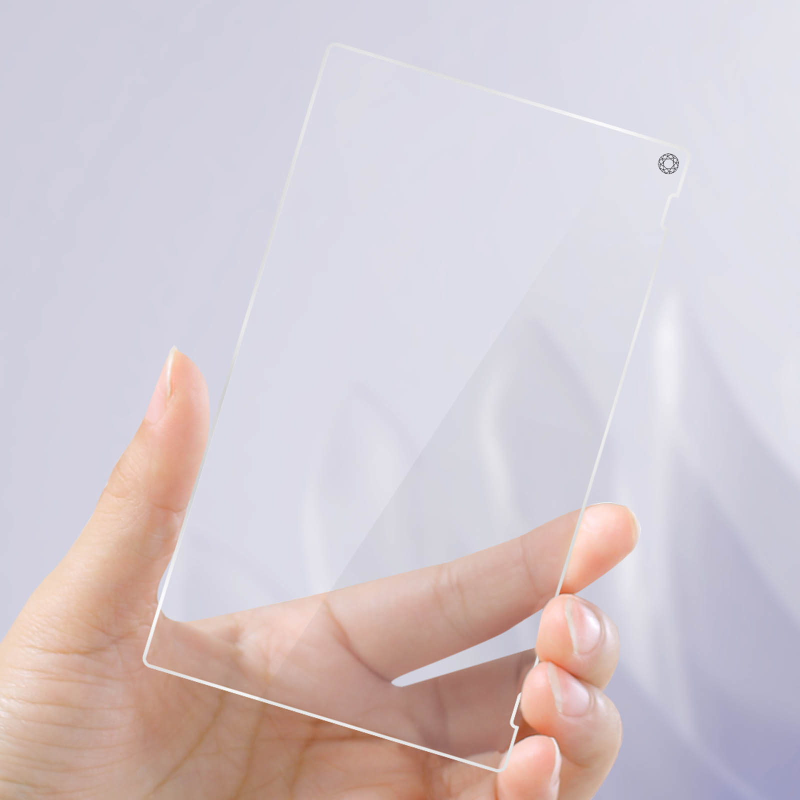 Una mano sostiene un trozo de cristal transparente y rectangular.