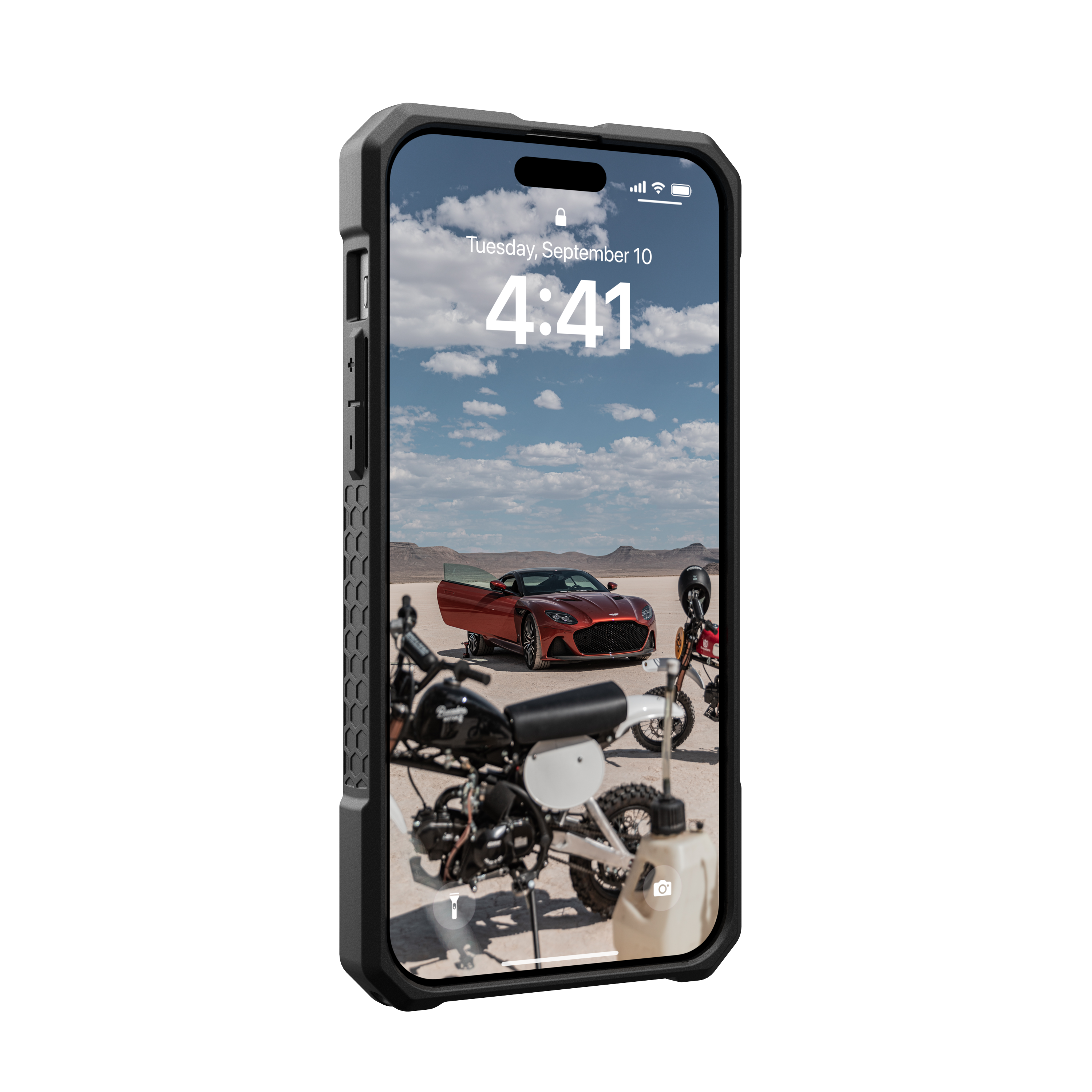Telefon, das ein Auto und Motorräder auf einer Wüstenstraße zeigt.
