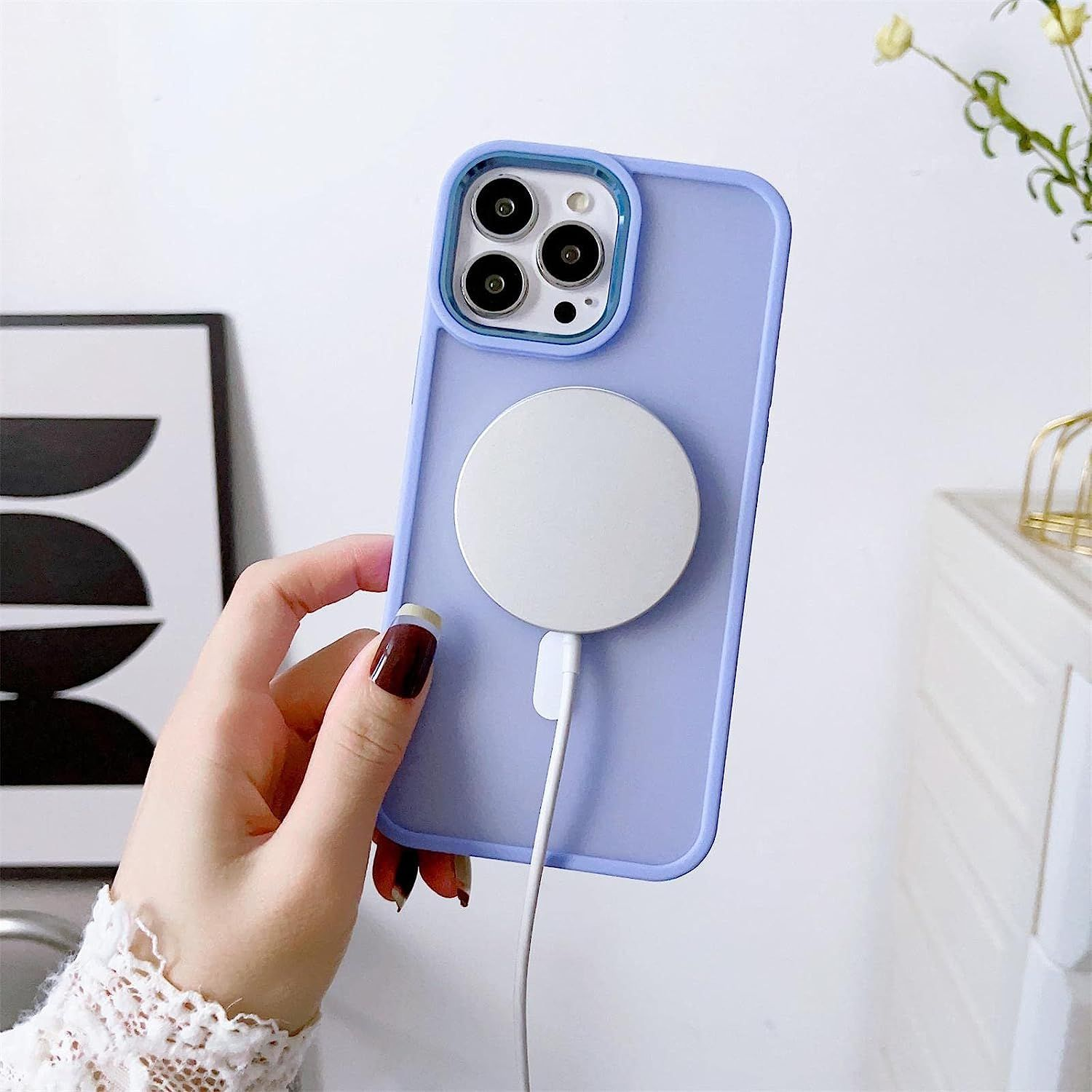 Hand hält ein Telefon mit weißem Ladegerät. Das Telefon hat eine lila Hülle und ein weißes Ladegerät.