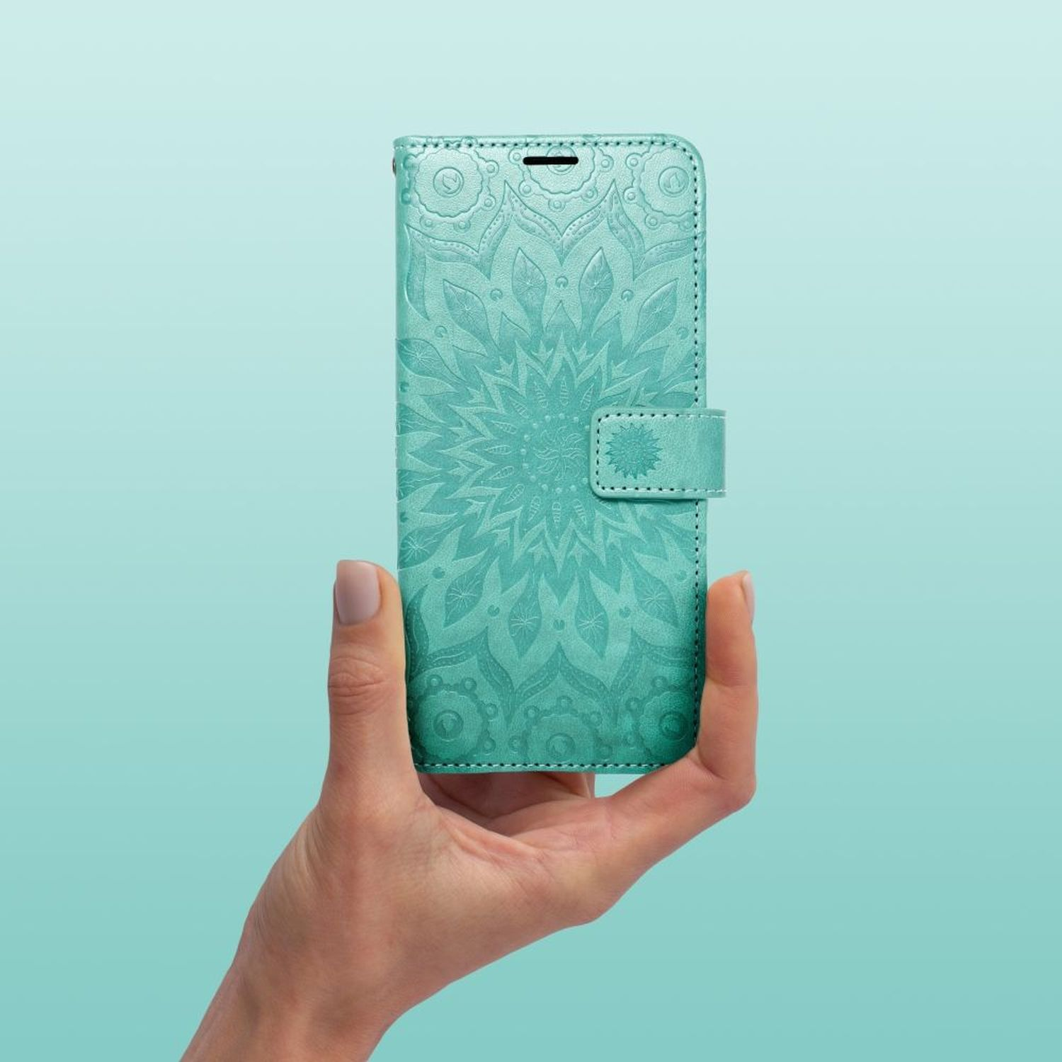 Hand hält eine türkisfarbene Handyhülle mit floralem Design. Türkisfarbener Hintergrund.