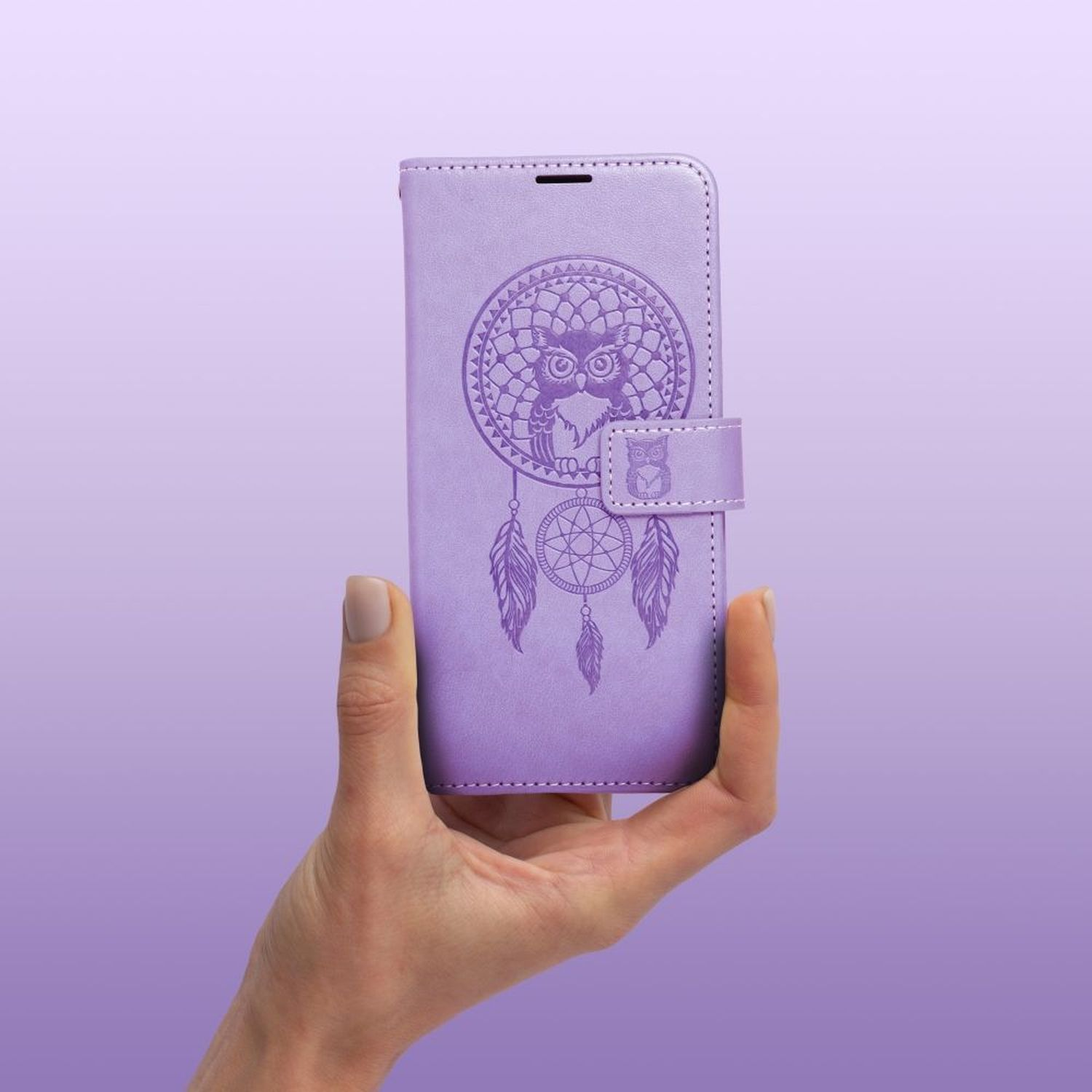 Eine lilafarbene Handyhülle mit einem Traumfänger- und Eulen-Design, gehalten von einer Hand.