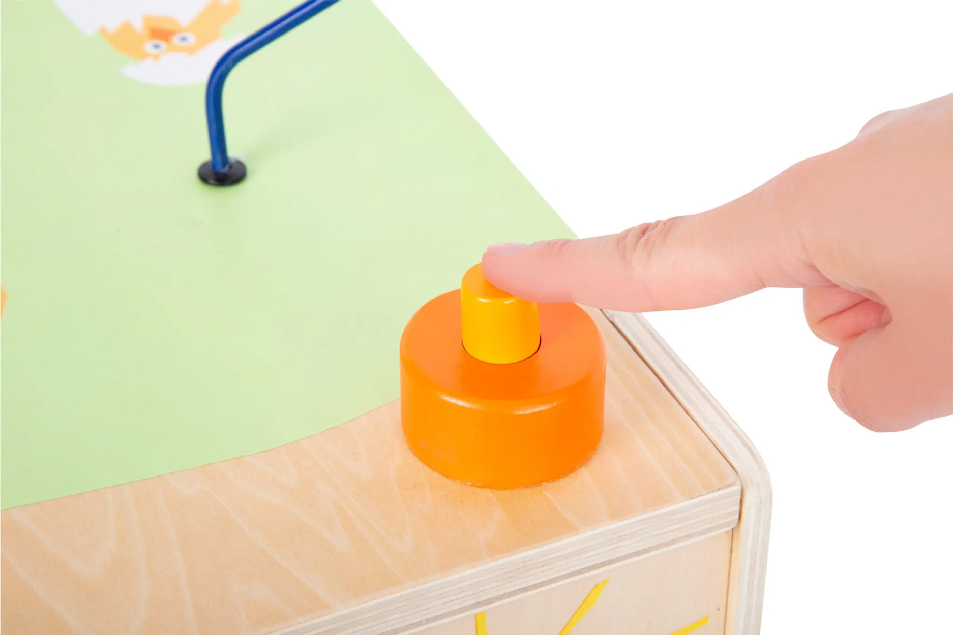 Ein Finger, der auf eine orangefarbene Taste auf einem Holzspielzeug drückt.