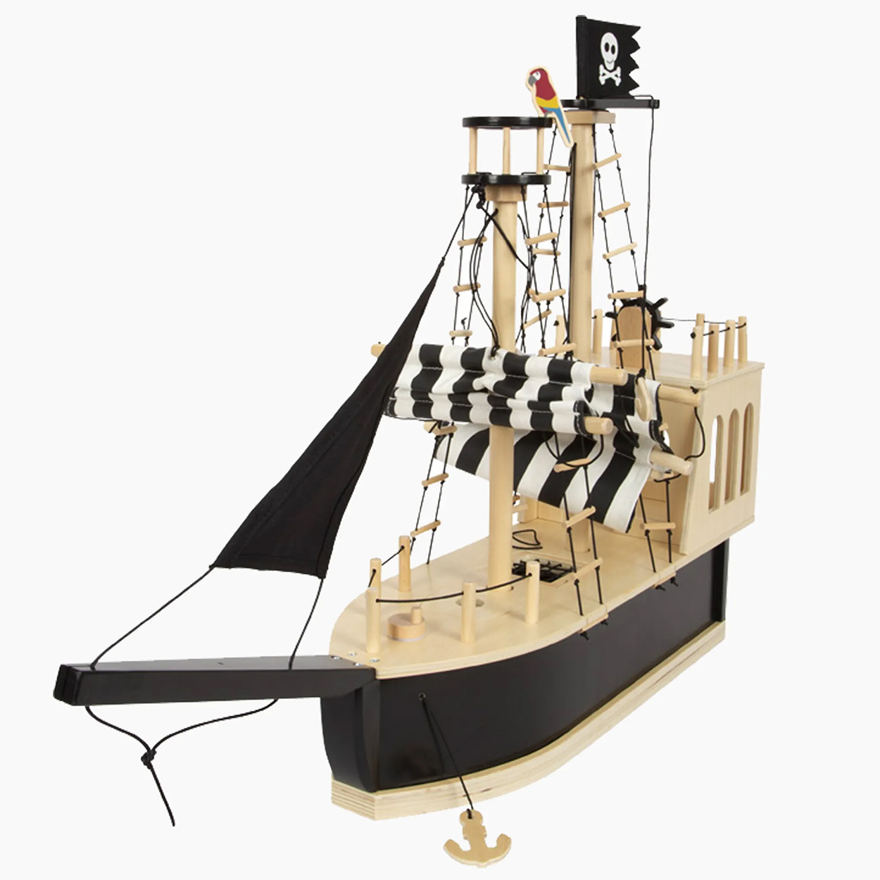 Un bateau pirate jouet en bois. Il a des voiles noires et blanches, un drapeau et un perroquet dessus.