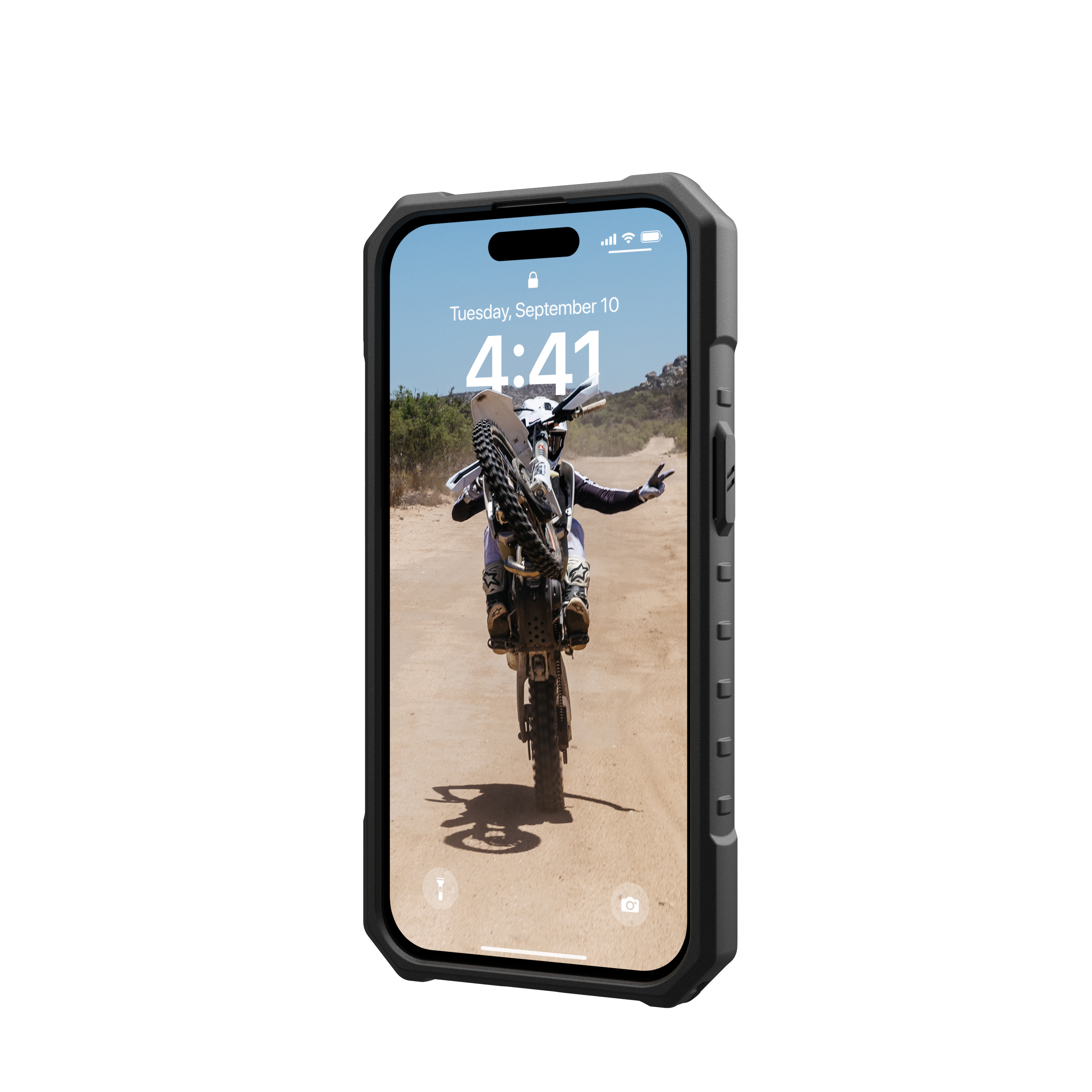 Uno smartphone in una custodia nera che mostra un motociclista che fa un'impennata su una strada sterrata.