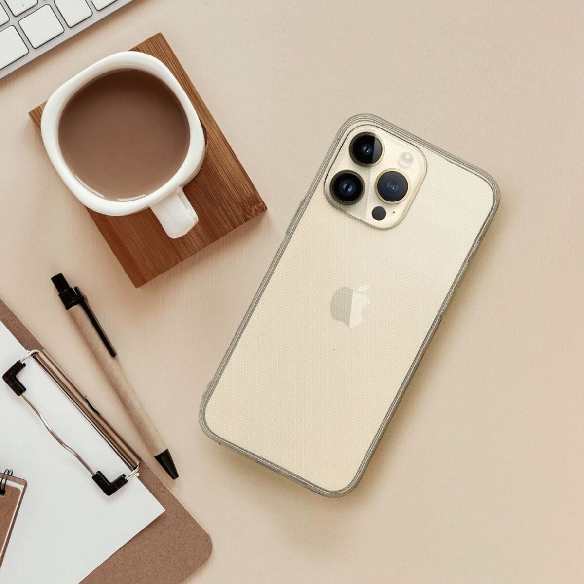 Ein Telefon mit durchsichtiger Hülle, eine Tasse Kaffee, ein Stift und ein Notizblock auf einem Schreibtisch.