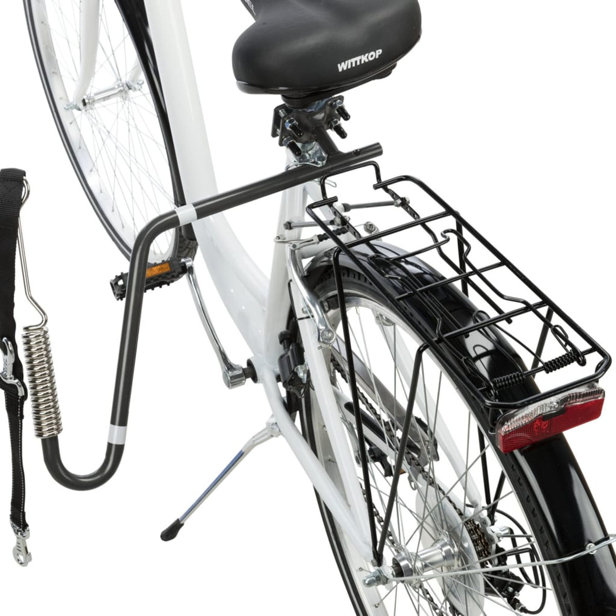 Una bicicleta con un portaequipajes negro adjunto en la parte trasera, con correa y muelle para perro.