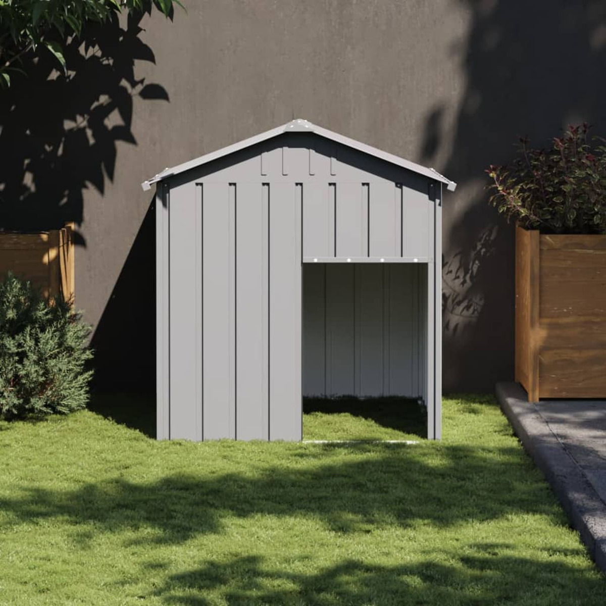 Ein graues Hundehütte mit rechteckiger Tür, in einem grasbewachsenen Bereich.