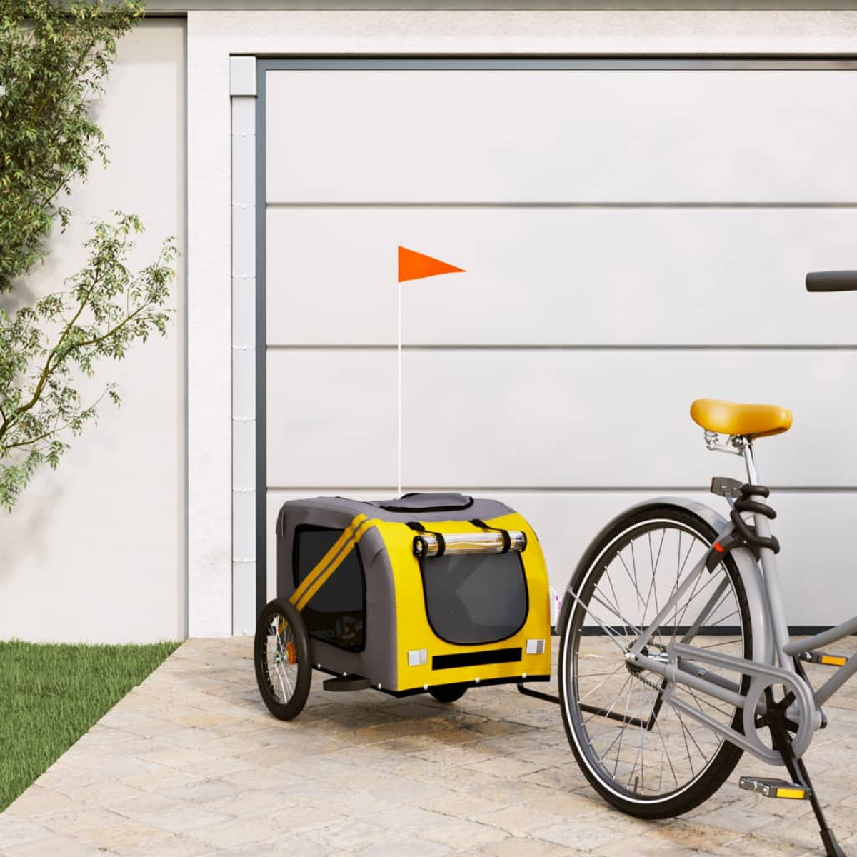 Gelber und grauer Hundeanhänger an einem Fahrrad befestigt. Eine orangefarbene Fahne ist befestigt.