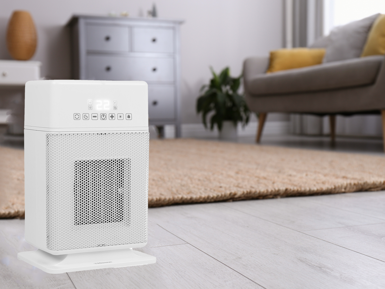 Weißer Elektroheizer mit Digitalanzeige, platziert auf Holzboden. Hintergrund ist ein Raum.