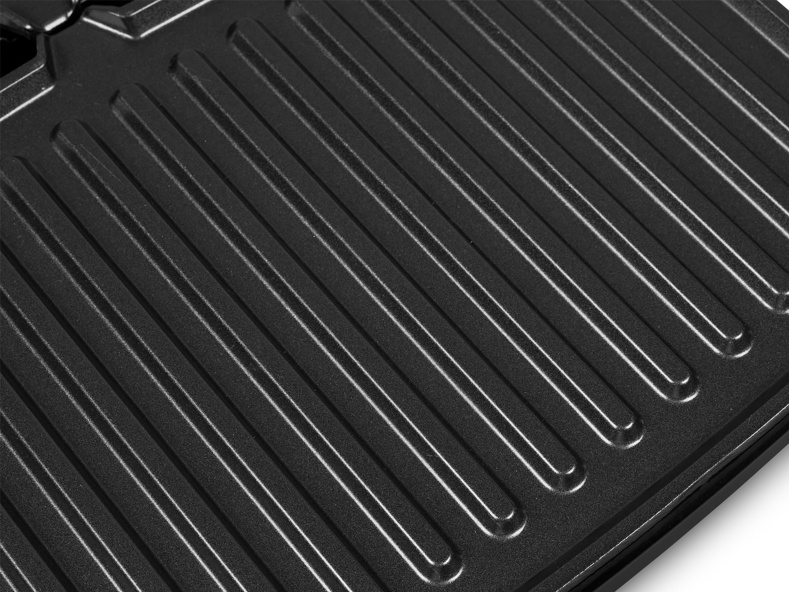 Nahaufnahme einer schwarzen Grillpfanne mit Rillen, die parallele Rillen zeigen.
