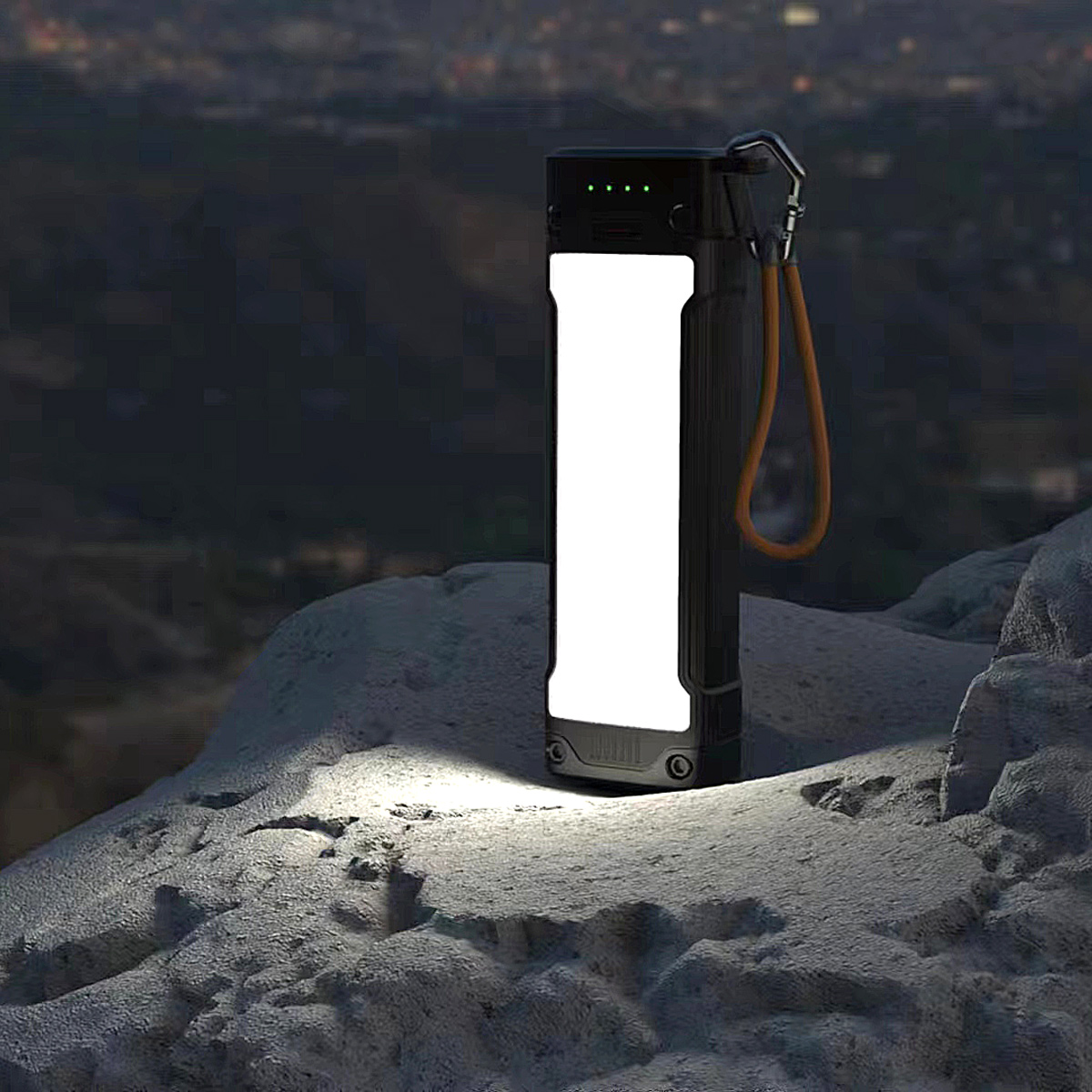 Schwarze Taschenlampe leuchtet nachts auf einem Felsen.