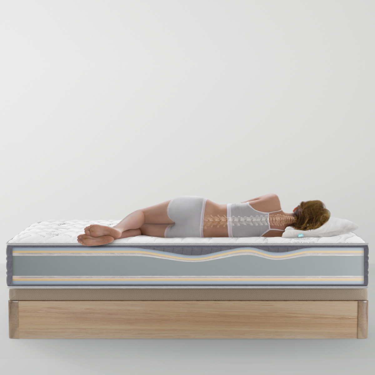 Mujer acostada en un colchón, mostrando la columna vertebral. Fondo blanco.