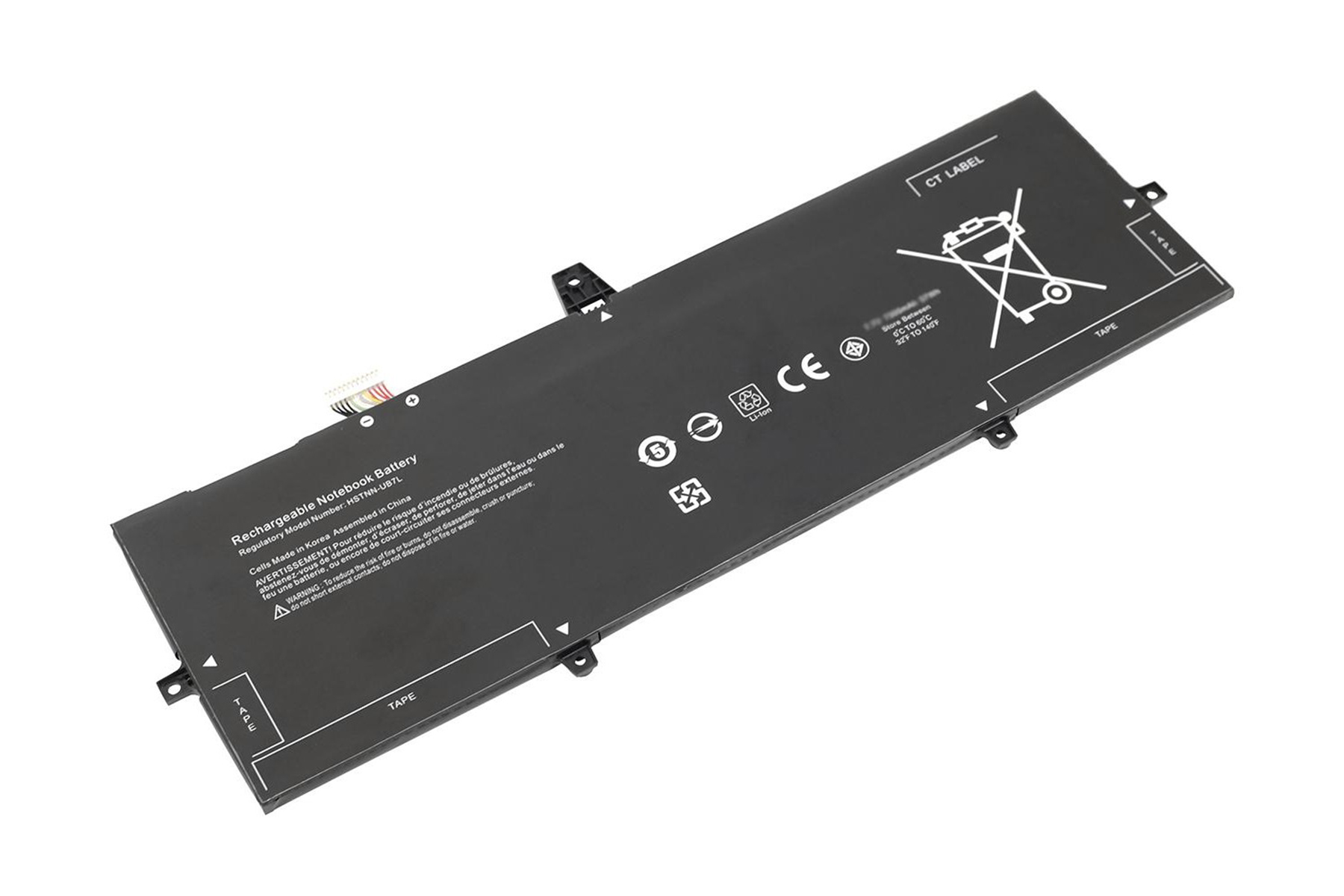 Una batteria ricaricabile per notebook nera con etichette e avvertenze. È appoggiata su una superficie bianca.