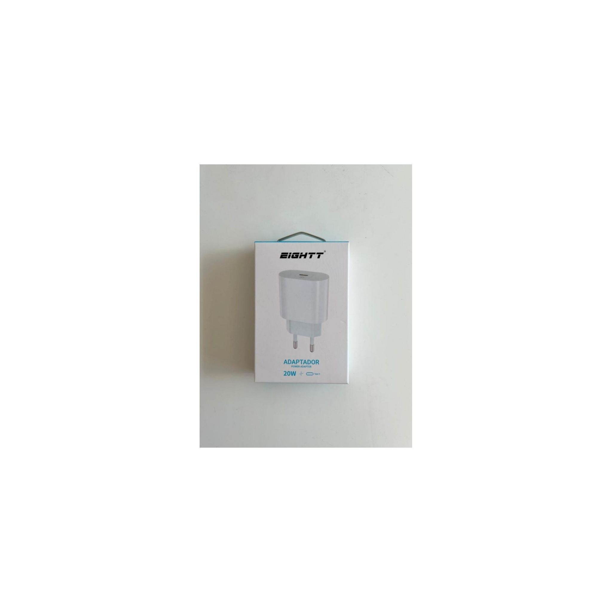 Una caja de cargador blanca con la etiqueta 'EIGHTT' y 'ADAPTADOR' se muestra sobre una superficie blanca.