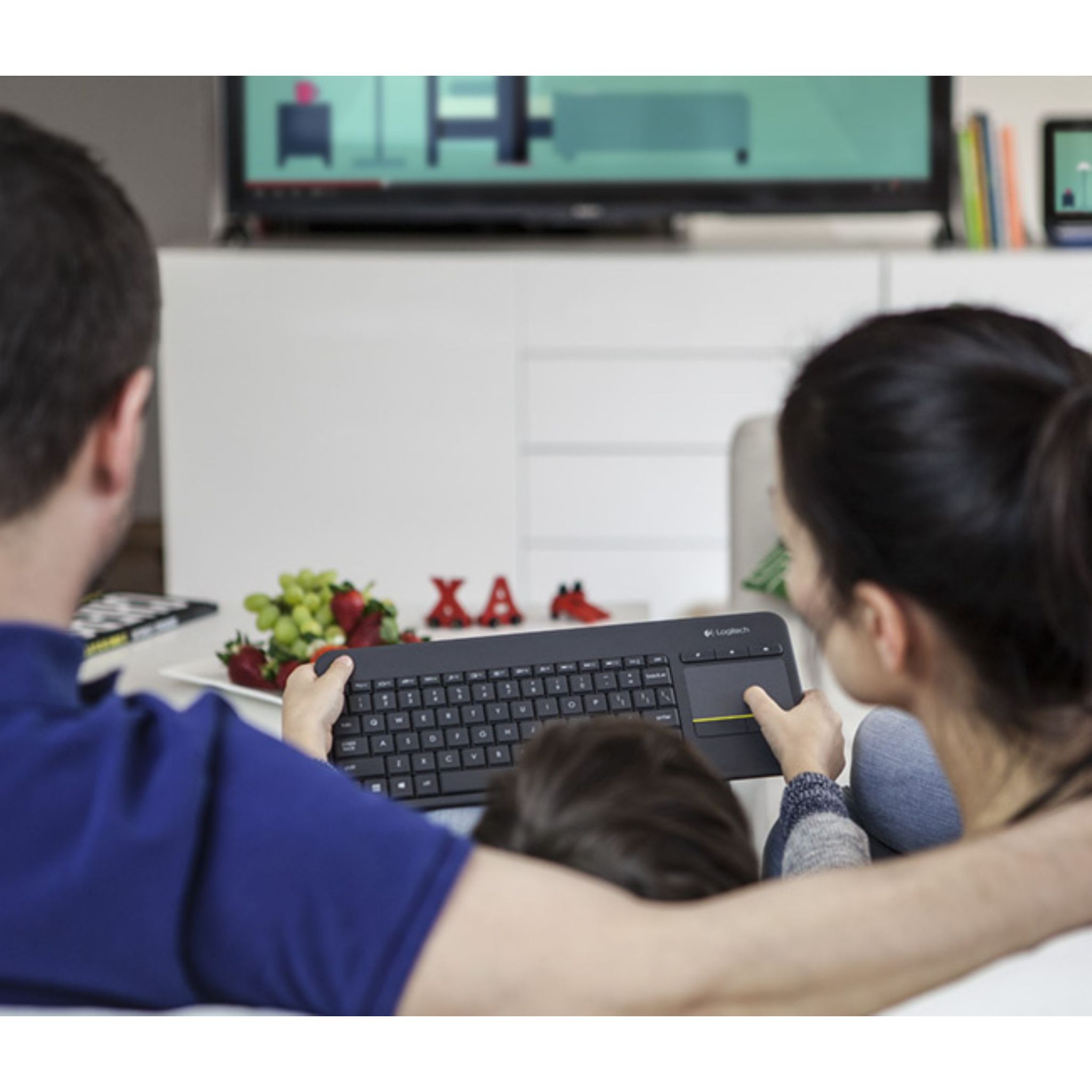 Familie kijkt tv, man en vrouw omarmen kind, vasthoudend toetsenbord met touchpad.