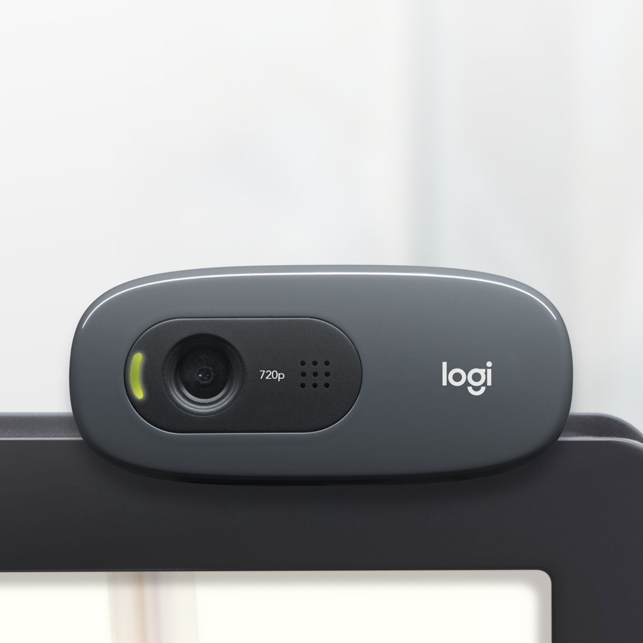 Graue Logitech-Webcam. Sie hat ein Objektiv, Mikrofonlöcher und eine Betriebsanzeige.