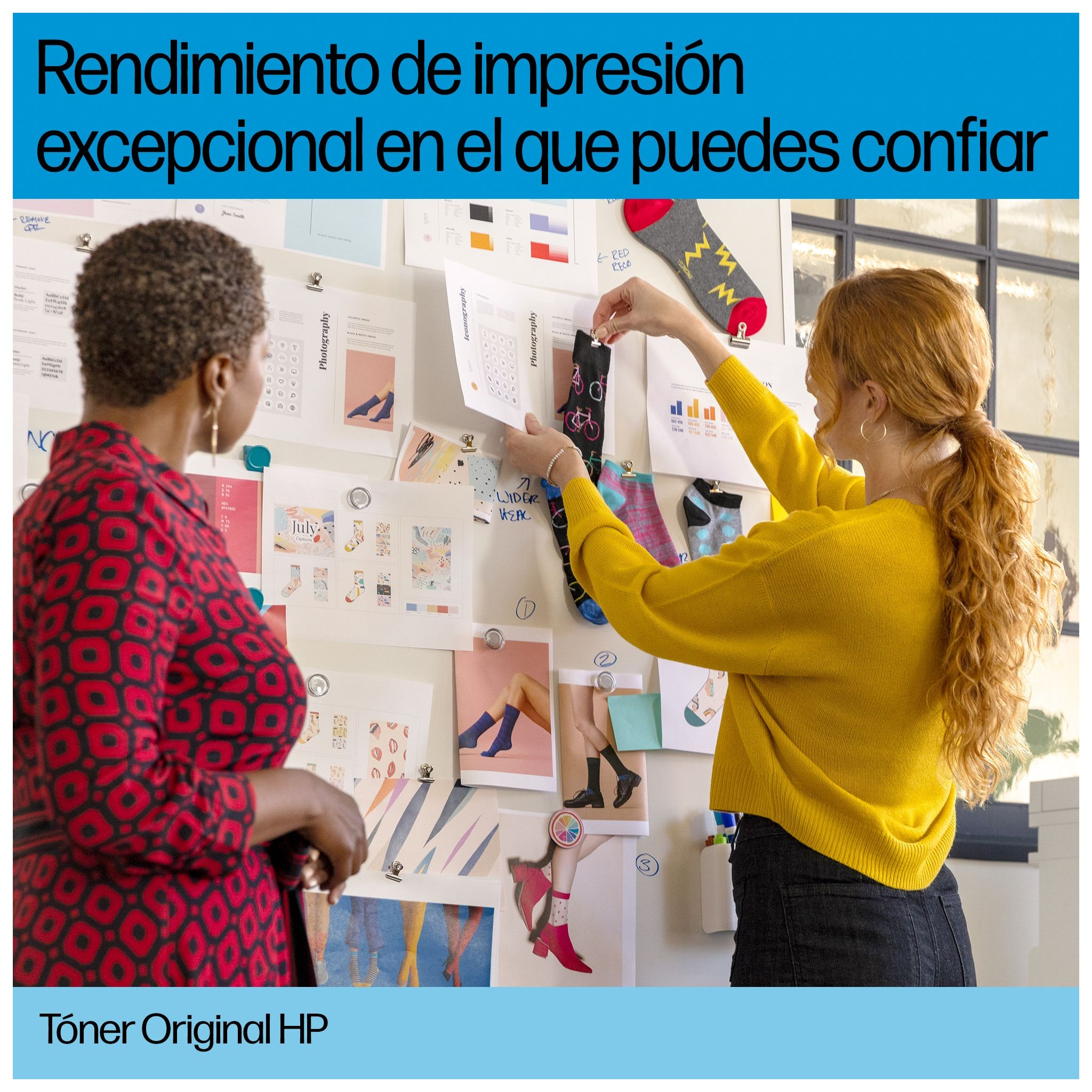 Dwie kobiety przeglądają papiery przymocowane do ściany. Jedna trzyma skarpetki, a druga patrzy.