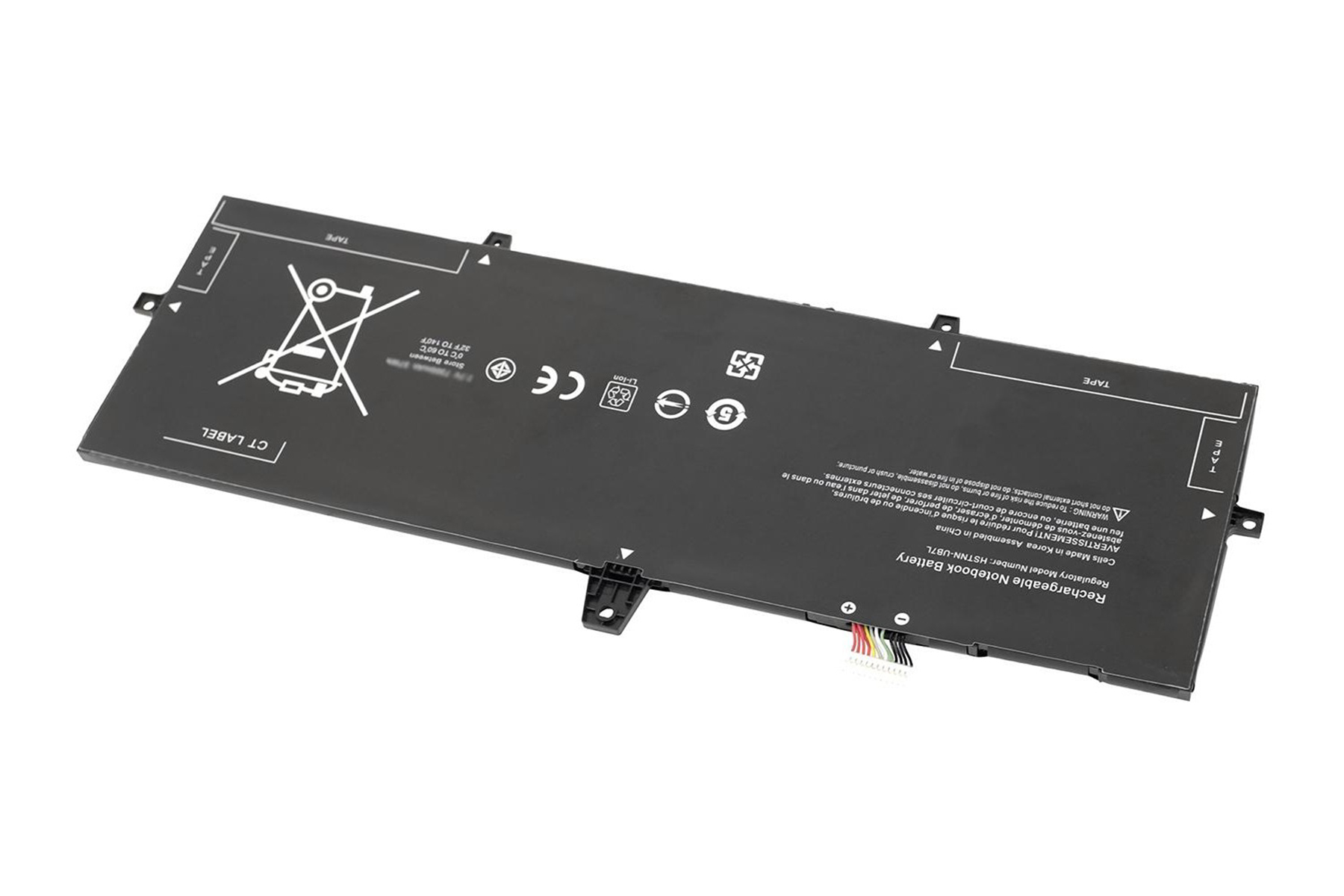 Una batteria rettangolare nera per laptop su una superficie bianca, con etichette e simboli.