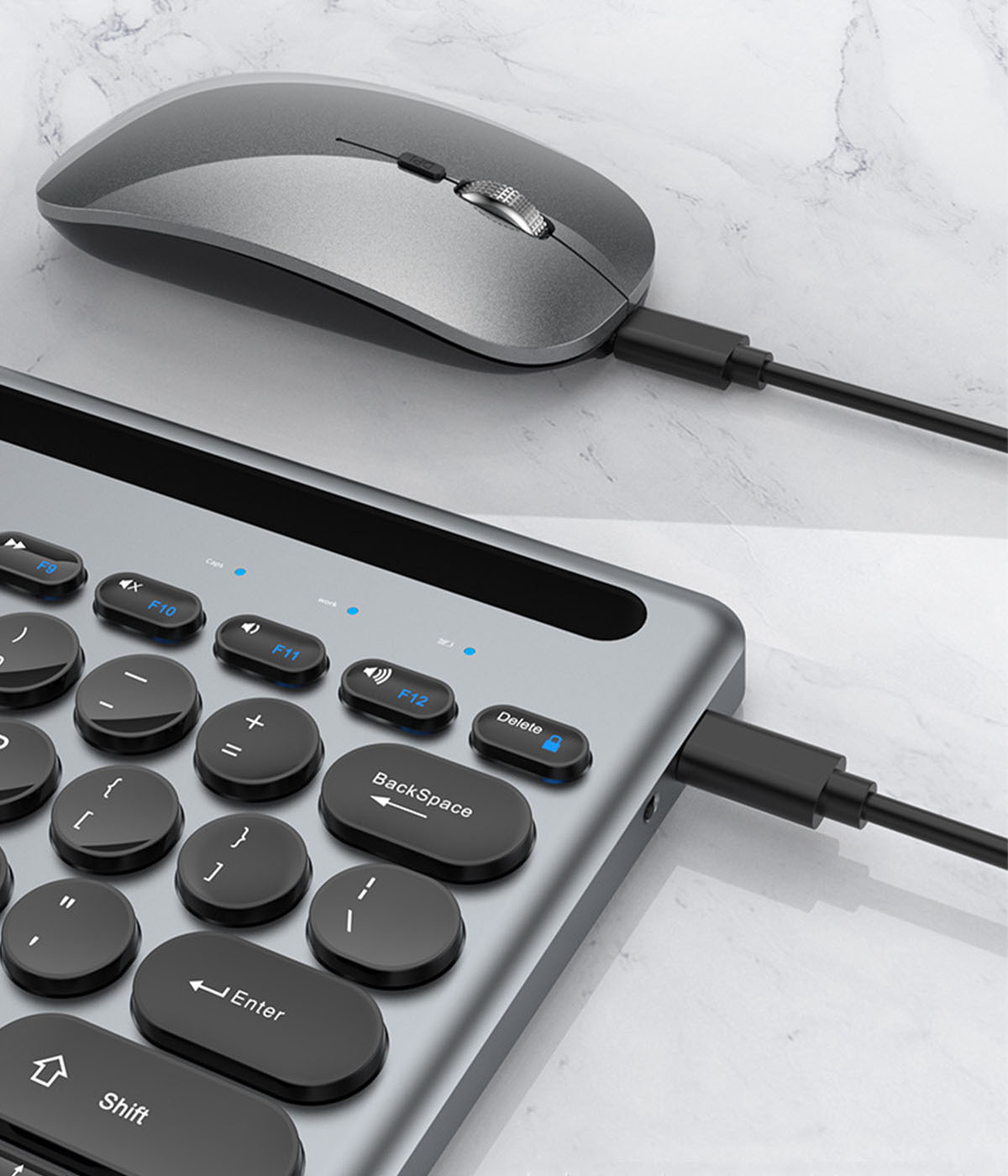 Kabelloses Tastatur- und Maus-Set, grau, schwarzes Kabel, auf Marmor.