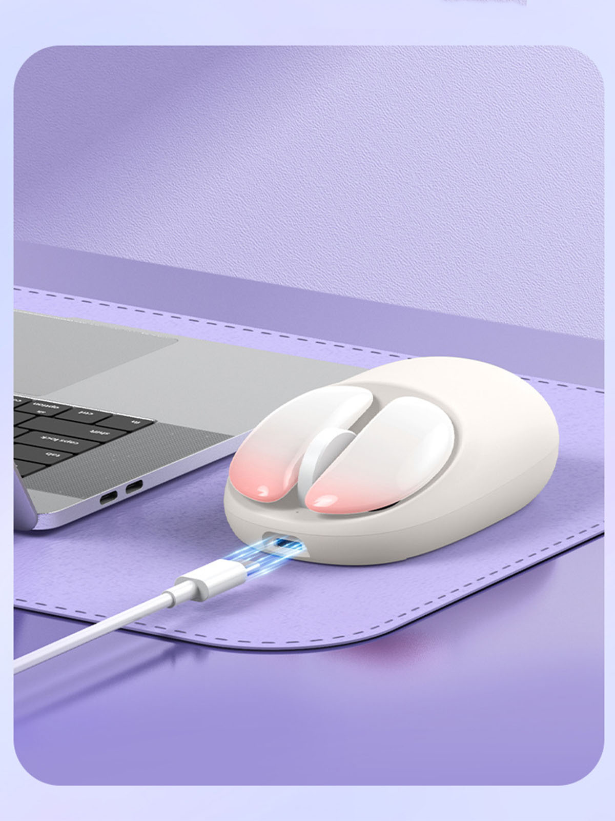 Weiße kabellose Maus, die auf einer lila Matte geladen wird. Laptop und Ladekabel sind sichtbar.