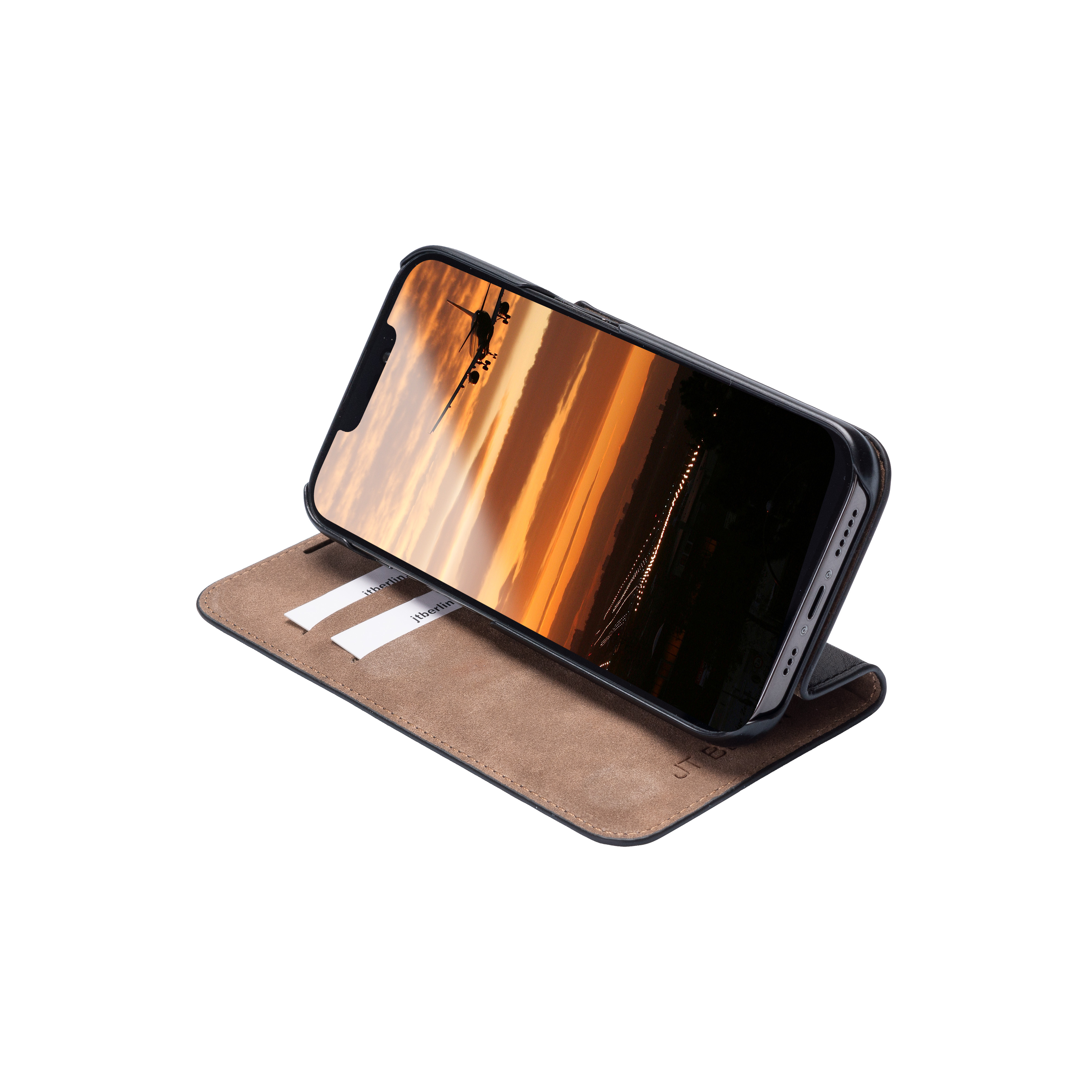 Téléphone sur un étui ouvert, montrant une scène d'avion, étui beige et noir.